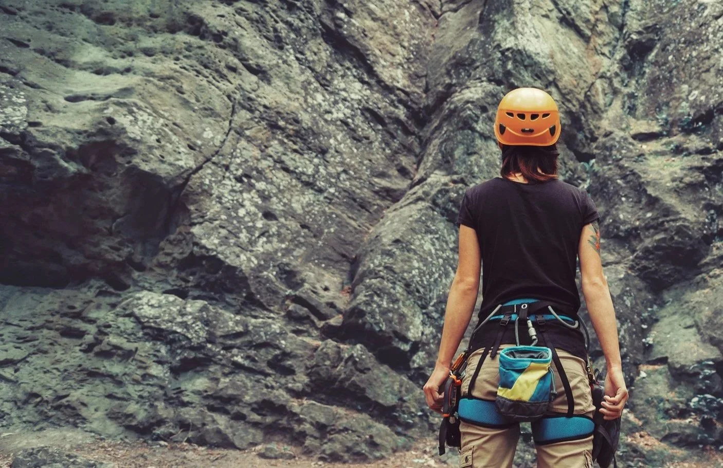 Woman wearing mountain climbing gear starring at a mountain