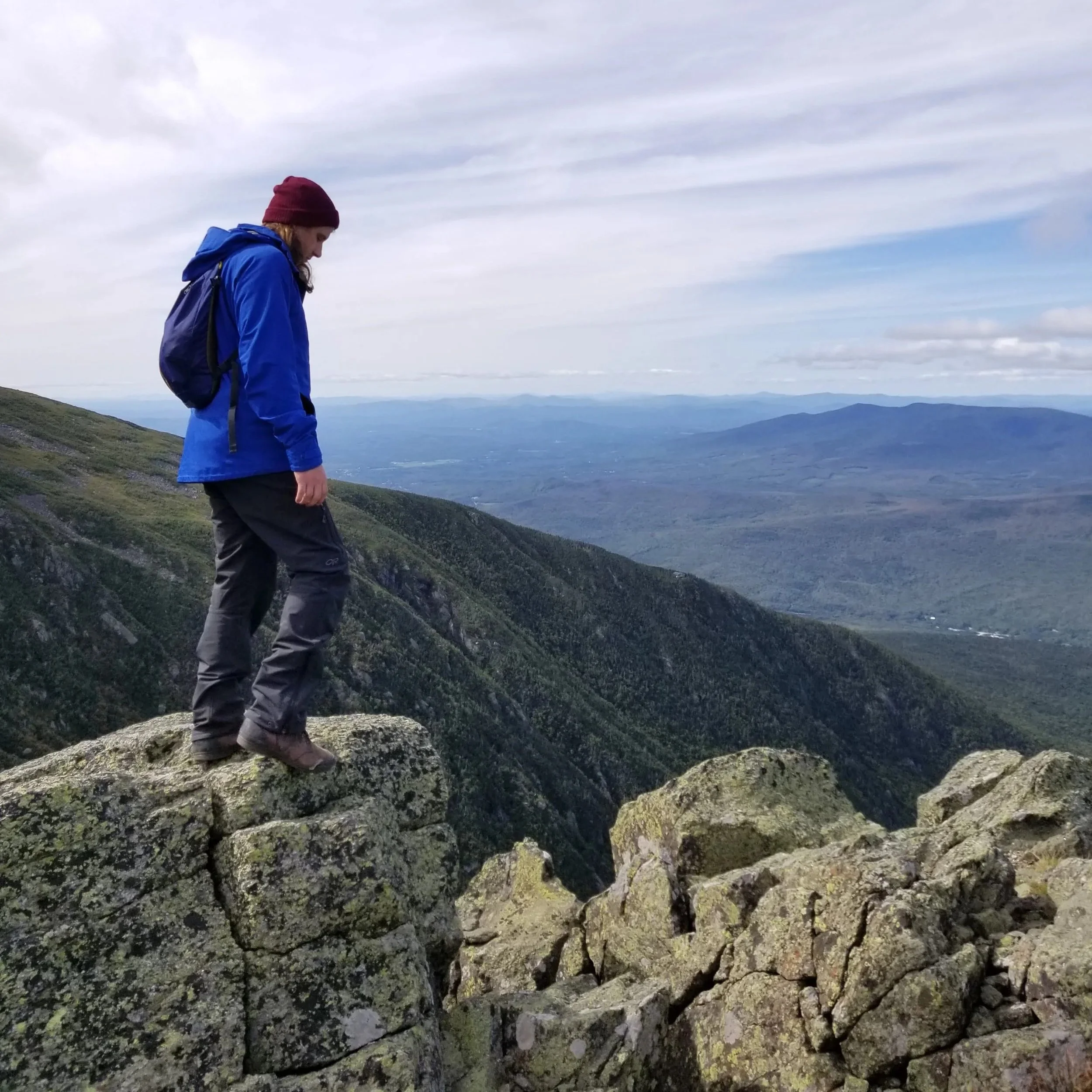 Derrick, founder of Outsider Gear Exchange, hiking over mountains