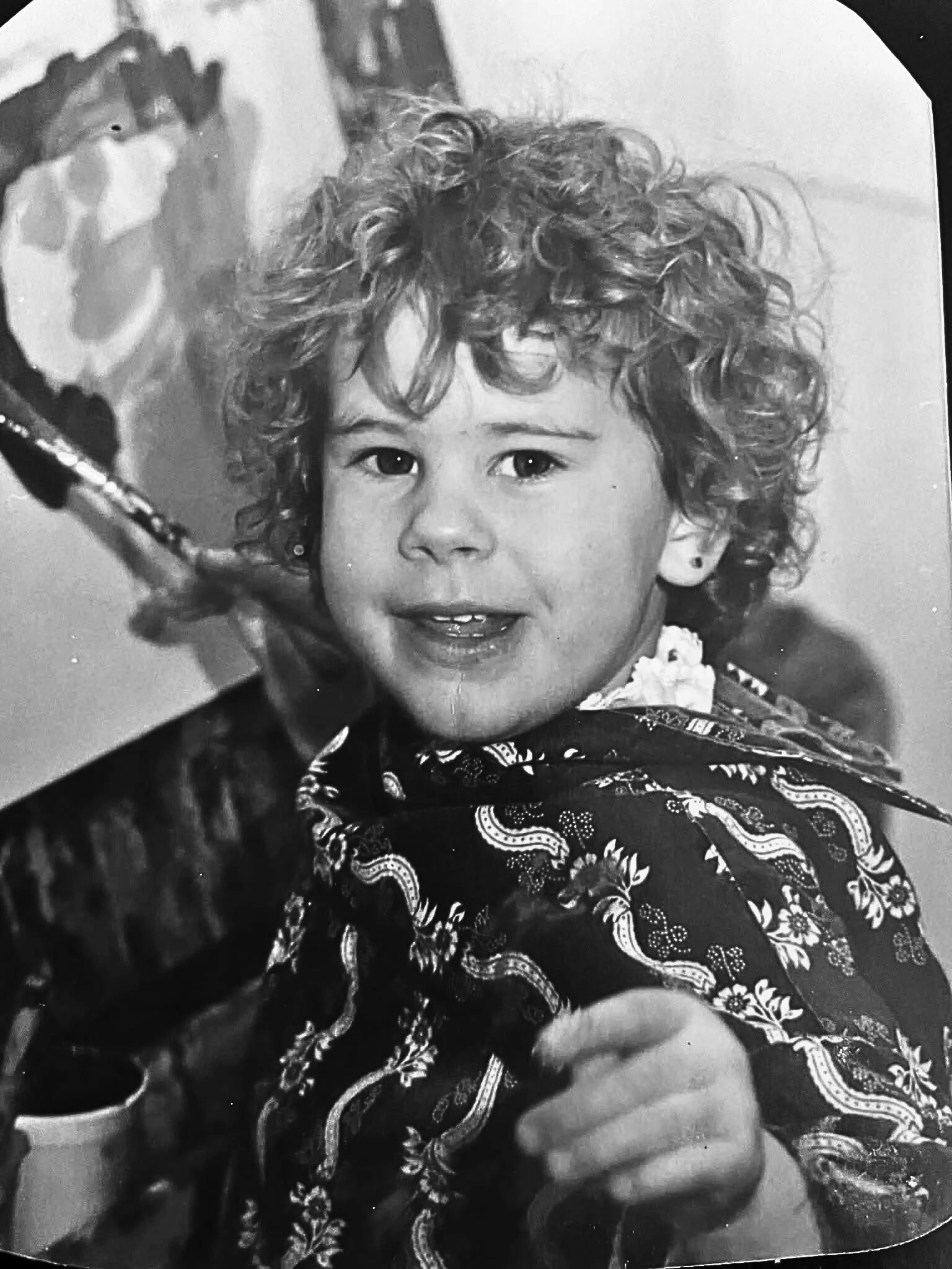 A photo of Michigan artist Erin Wilson in preschool painting at an easel.