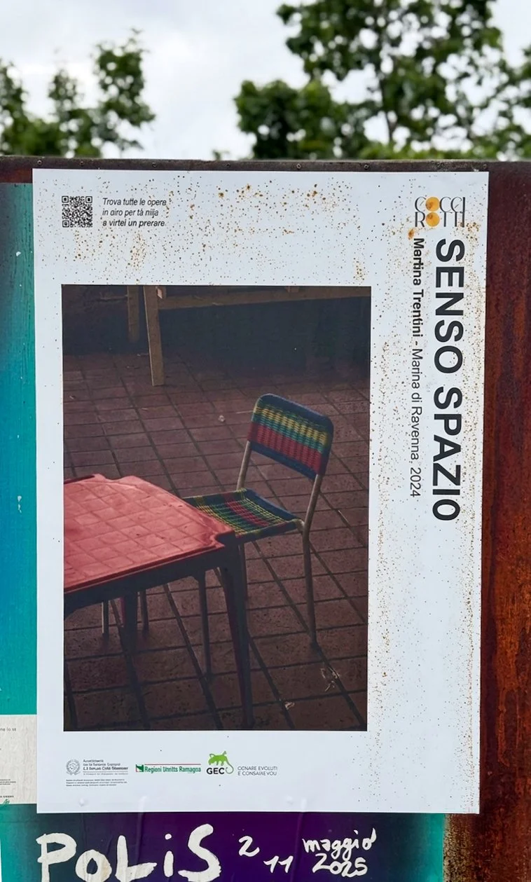 Un cartellone pubblicitario con una foto di una sedia colorata e un tavolo su una terrazza in ceramica.