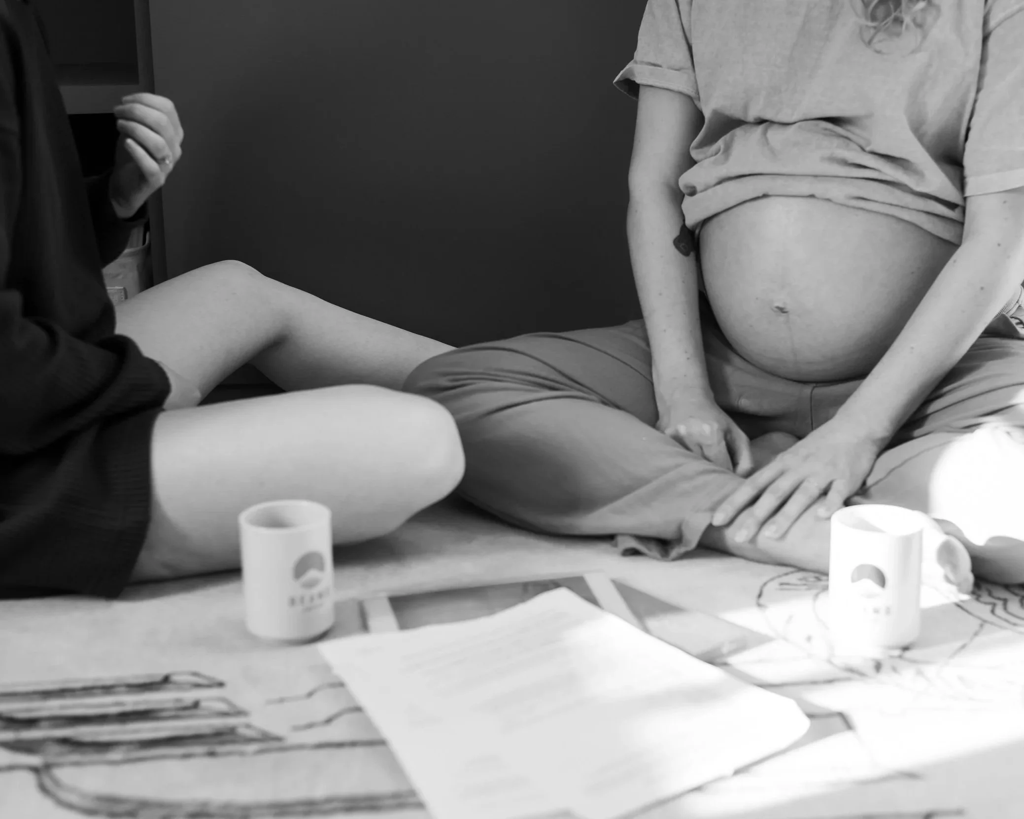 Une doula et sa cliente enceinte dans son troisième trimestre de grossesse discutent du projet de naissance. Elle boivent un thé et son détendues. La doula donne de l'information et écoute la femme enceinte. 