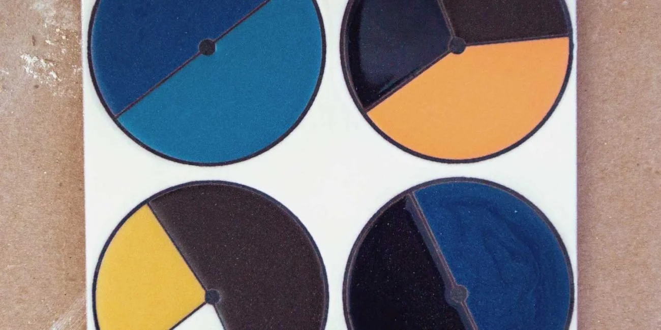 Four circular color chart discs with segmented color sections placed on a white surface.