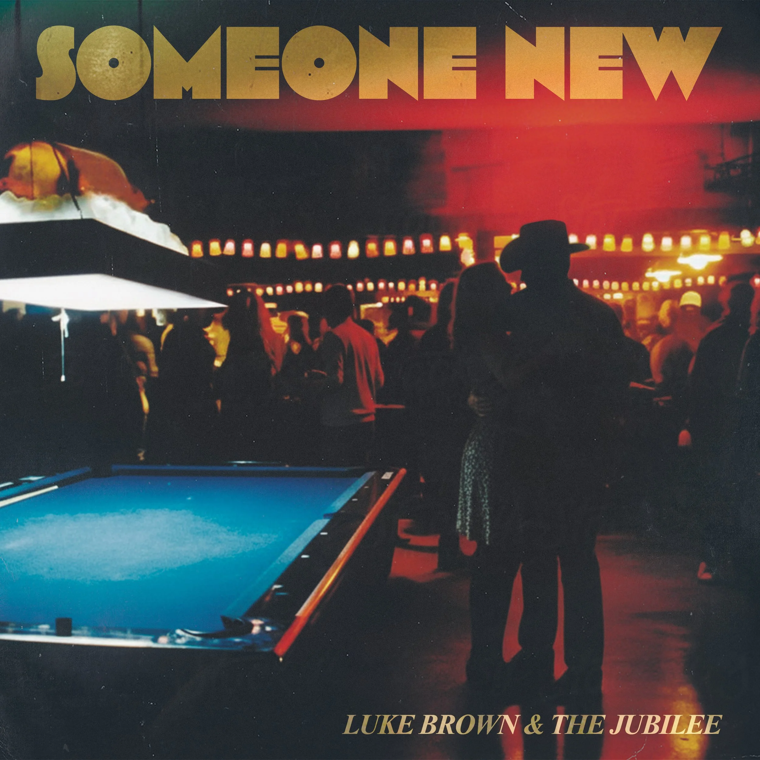 Silhouettes of people gathered at a lively nighttime event with red and orange string lights and lanterns, a pool table in the foreground, and the text "Someone New" at the top and "Luke Brown & The Jubilee" at the bottom.