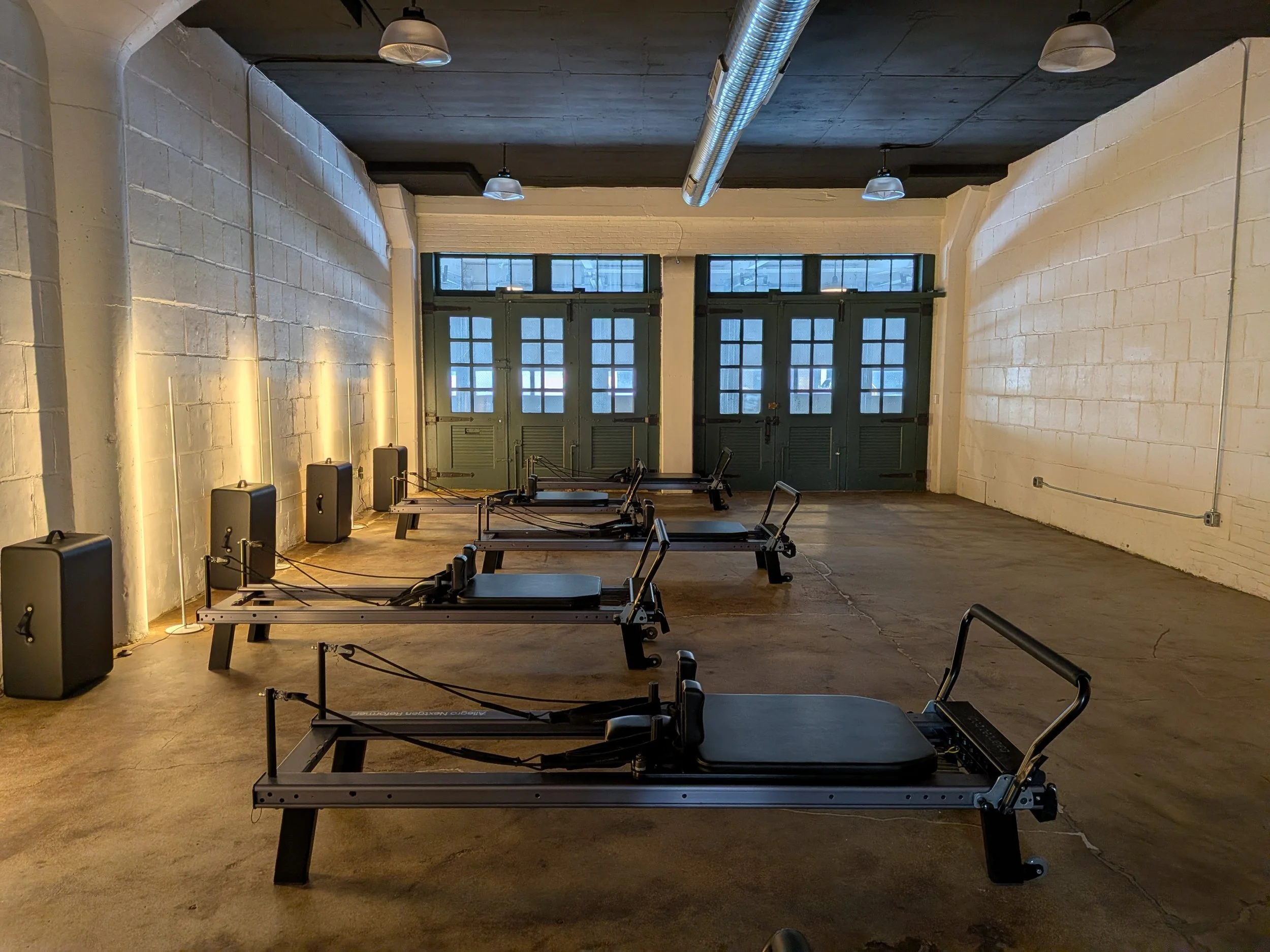 Pilates reformers in the main studio space of Form and Function PIlates, which offers small group classes aimed at improving strength and flexibility while minimizing joint impact and postural strain