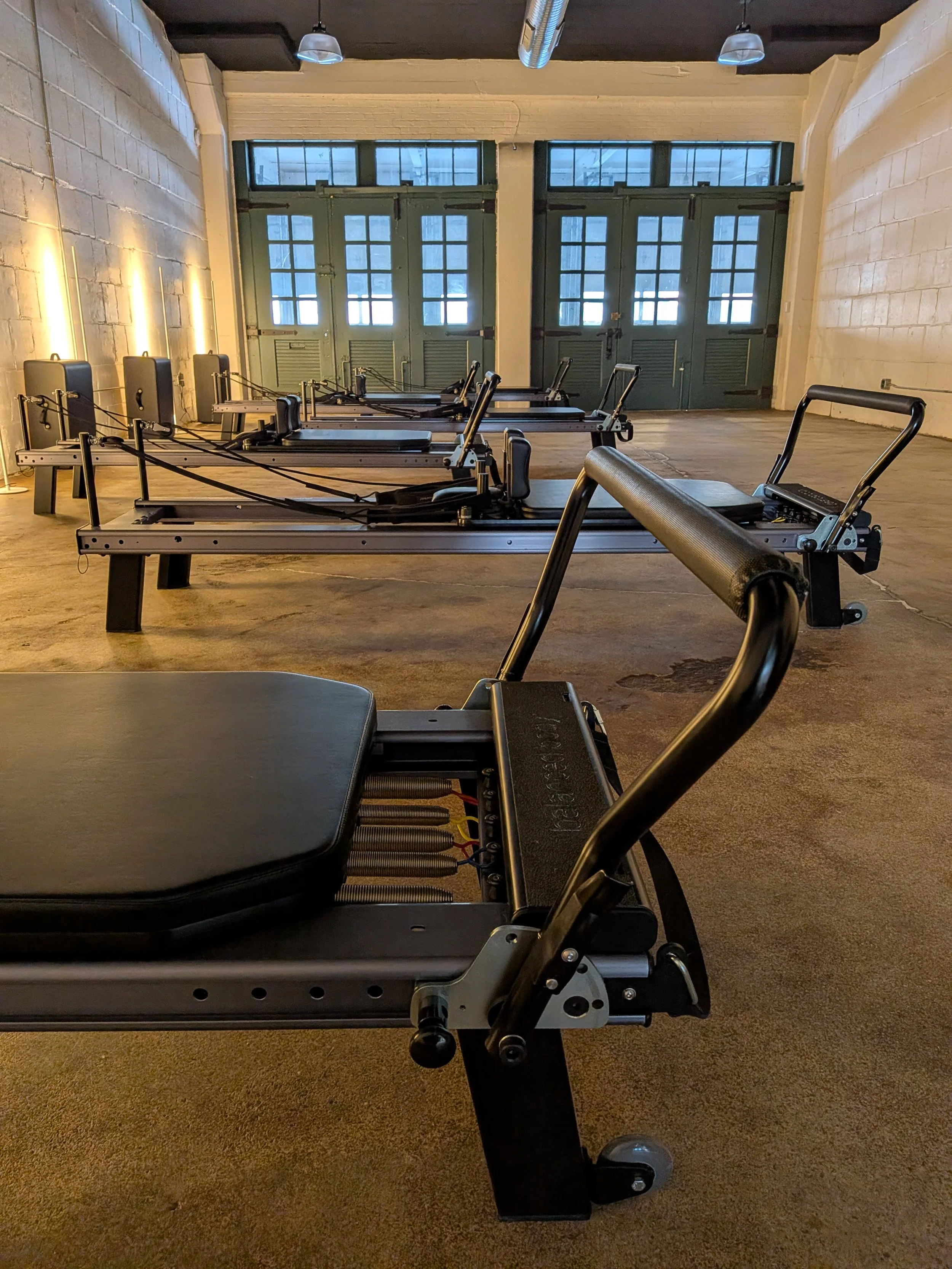 The pilates reformers in the studio space at Form and Function Pilates in Buffalo, New York. These are the reformers that participants use while taking small group reformer classes.