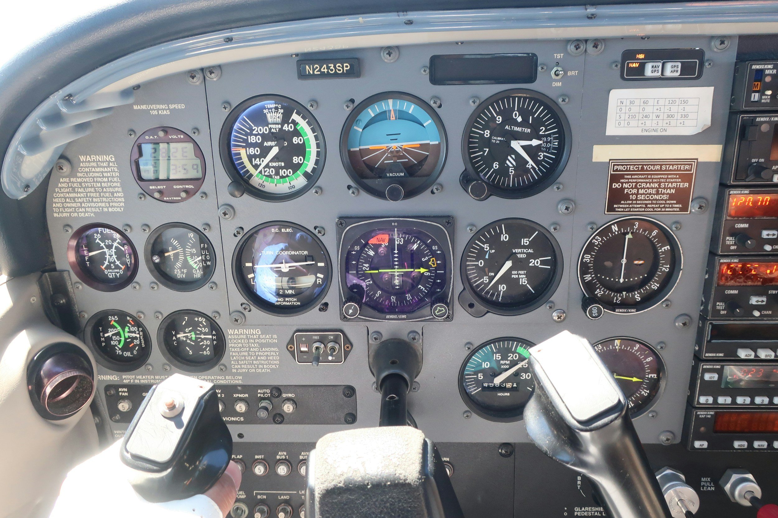 Aircraft cockpit instrument panel with various gauges and controls, including altimeter, airspeed indicator, and navigation instruments.