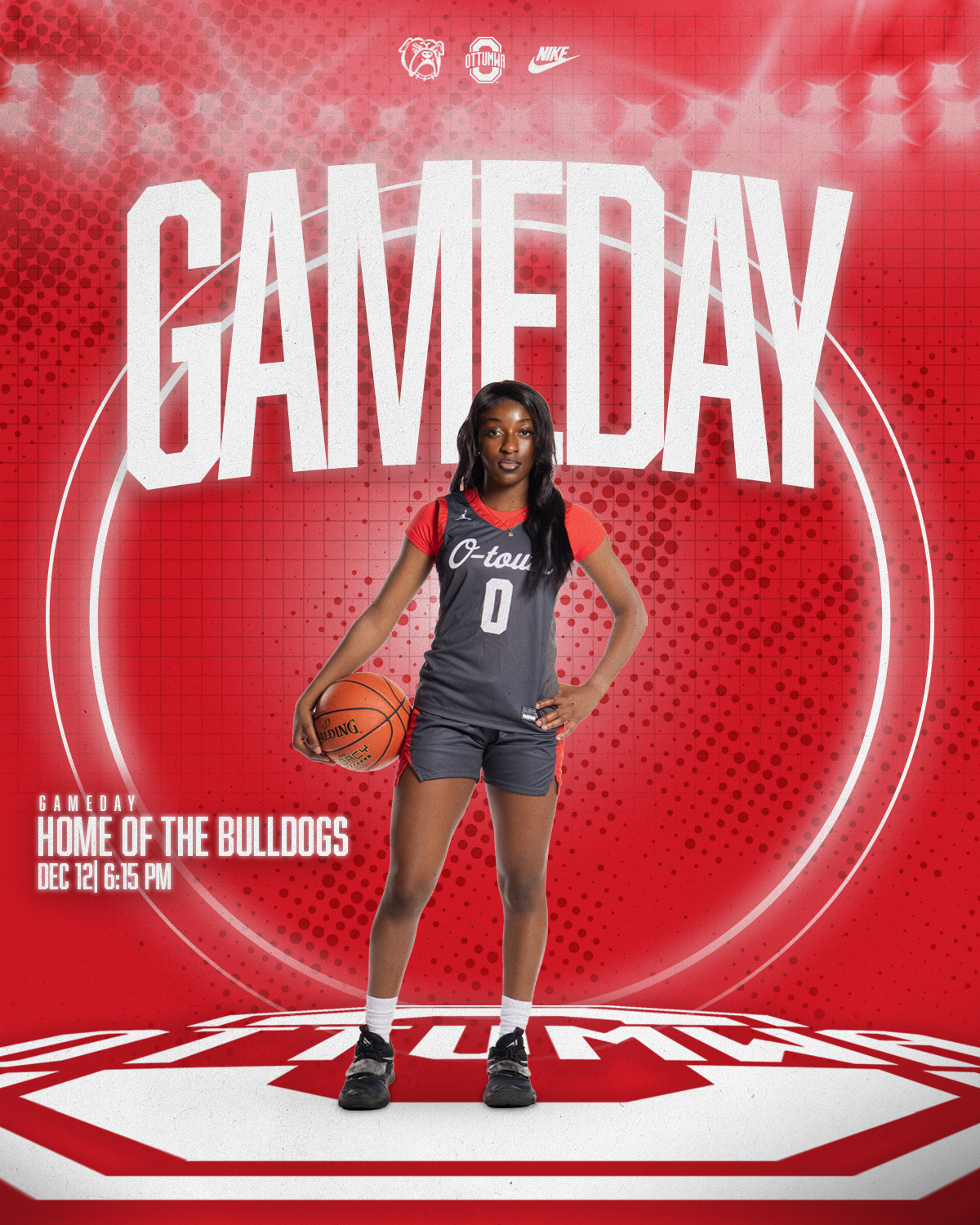 A basketball player standing on a court with a red background, holding a basketball, wearing a gray and red uniform with the number 0, in front of a promotional poster for a game on December 12th at 6:15 PM, indicating the home of the Bulldogs.