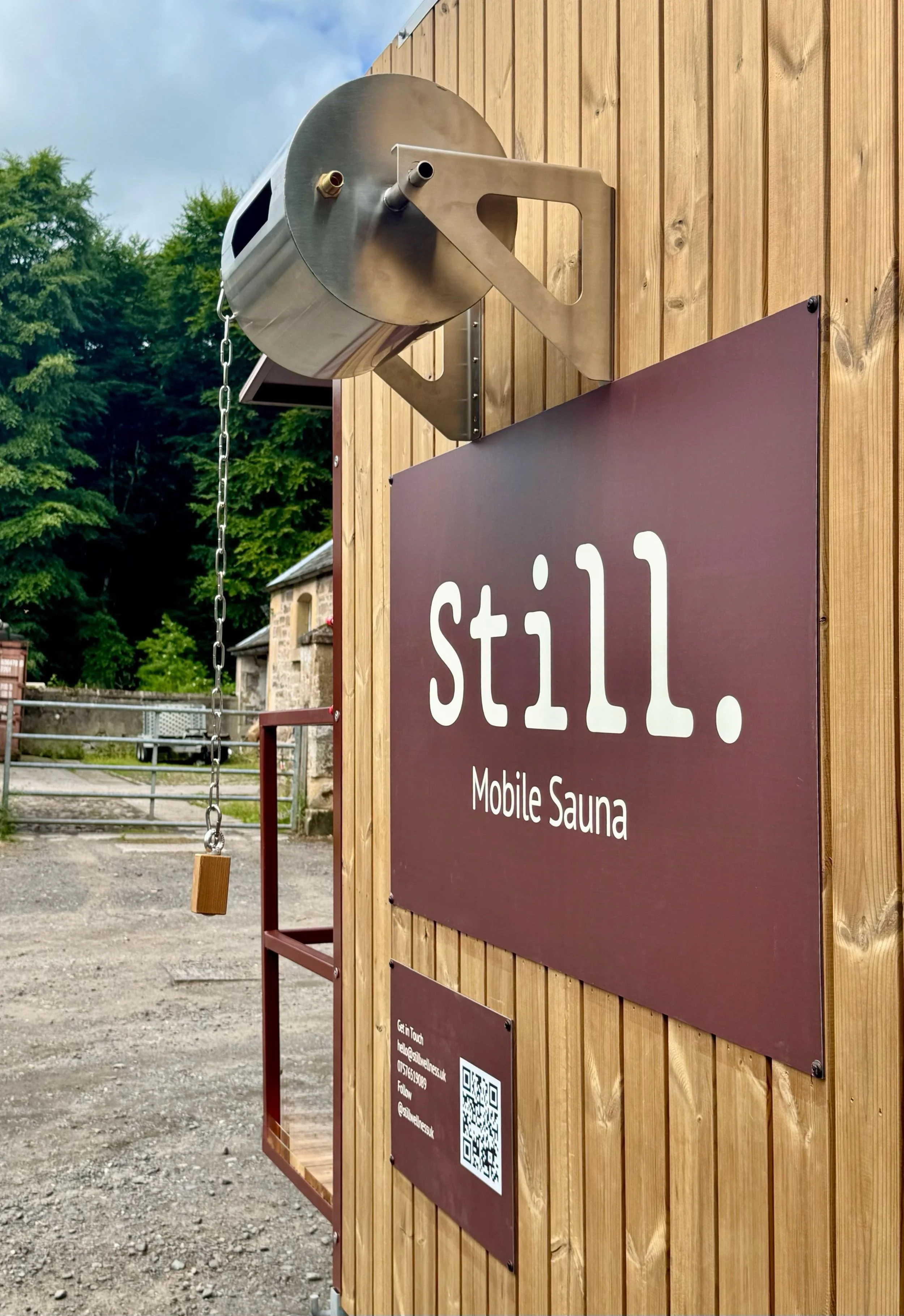 Still Wellness Sauna Trailer rear view, Mobile sauna back view showing stainless steel waterfall bucket along with branding for Still Wellness and contact details hire sauna trailer edinburgh, Sauna Trailer Scotland