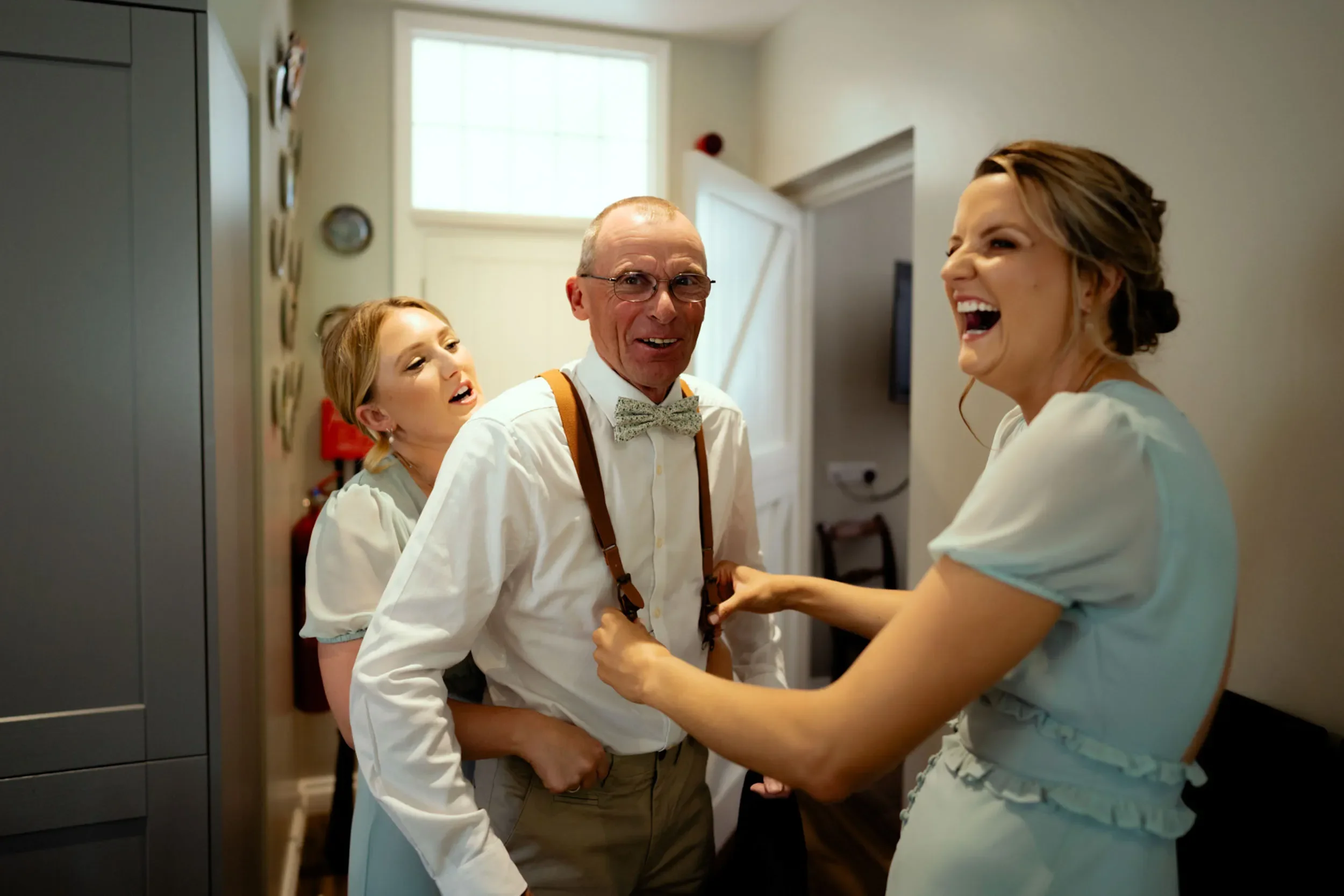 Four people laughing and having fun indoors.
