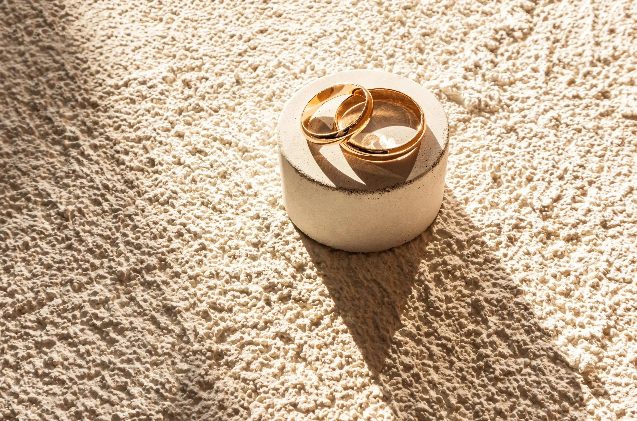 Two gold wedding rings on the beach