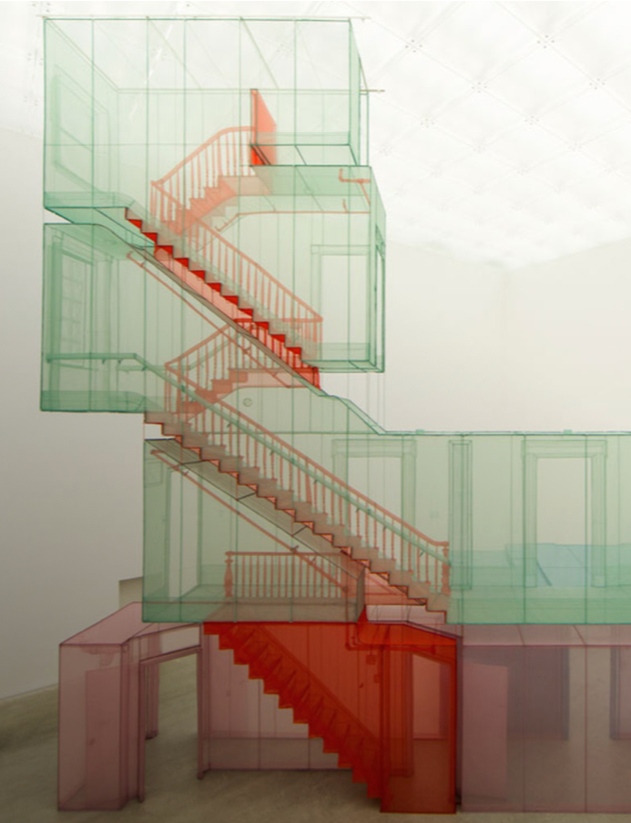 An art installation features multiple transparent, colored cuboid structures with internal staircases, layered vertically and horizontally, creating a multi-level visual effect.
