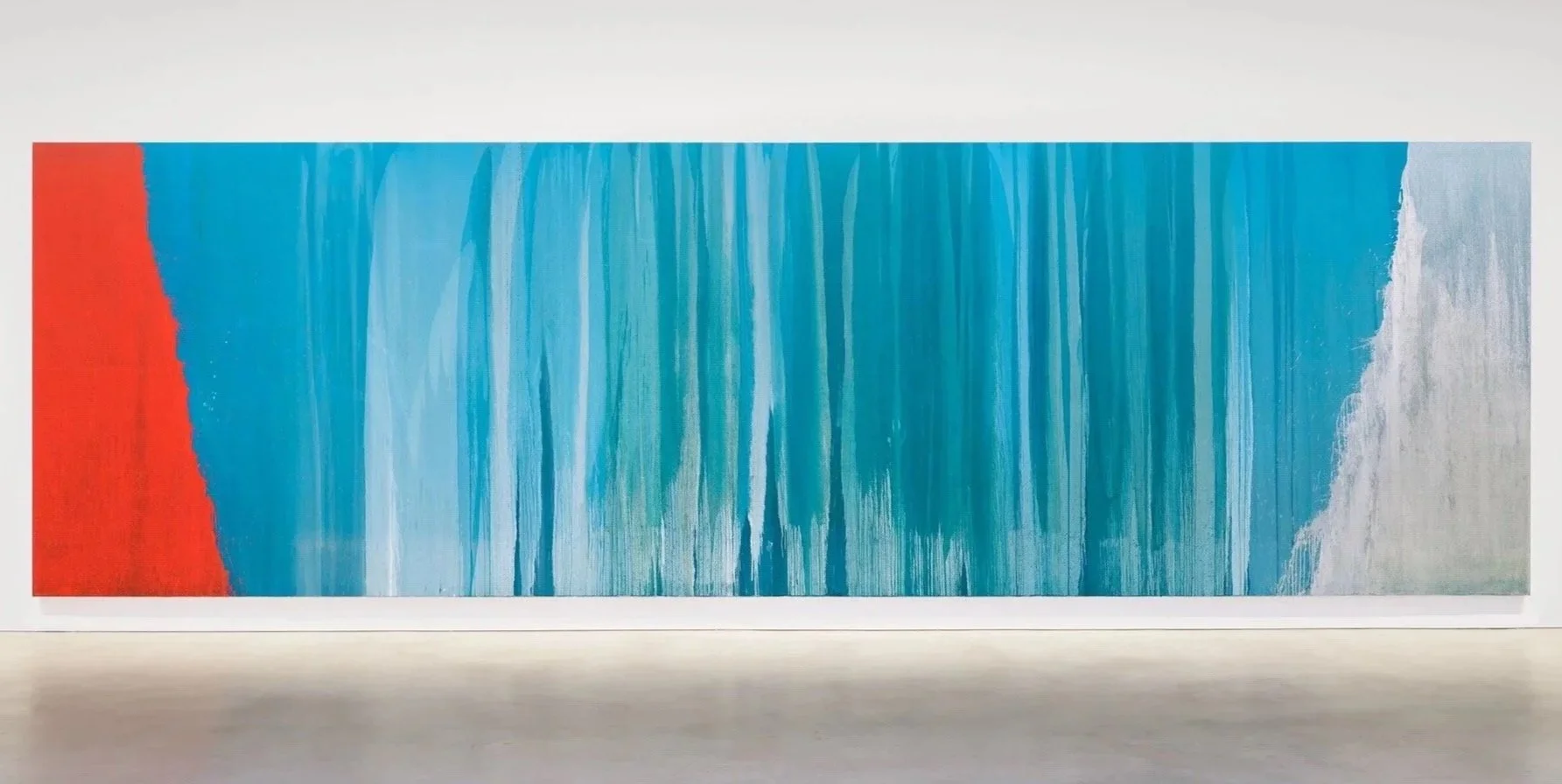 Abstract art piece with a red section on the left, transitions into blue shades with vertical streaks, and ends with a grayish-white section on the right.