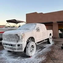 White pickup truck covered in snow parked outside a building.