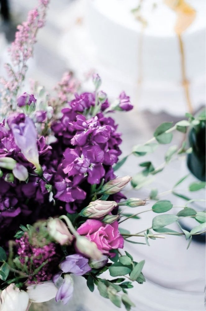 Close-up of lush purple and pink floral arrangement with roses and sweet peas