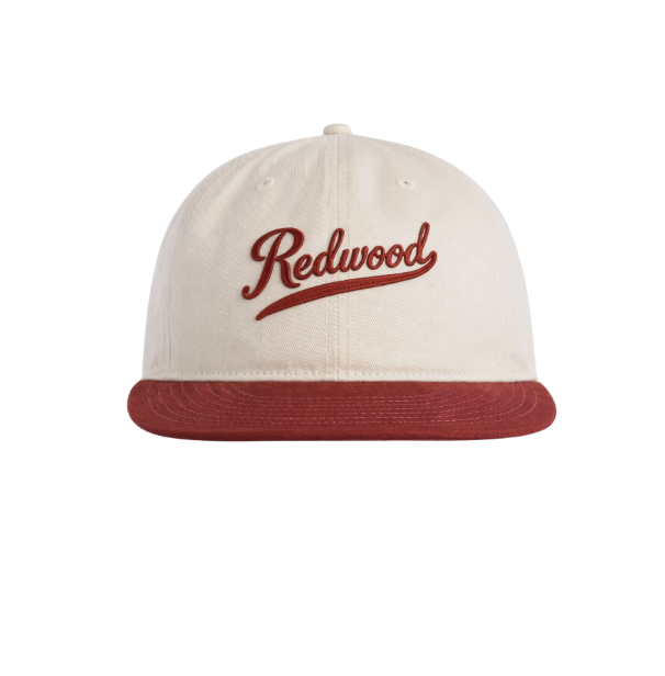 A baseball cap with a beige crown, red brim, and red embroidered 'Redwood' logo on the front.