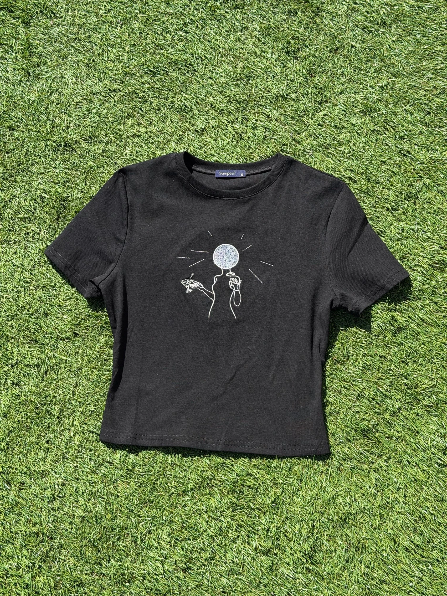 Womens silouette holding a martini with a disco ball head on a black crop top.