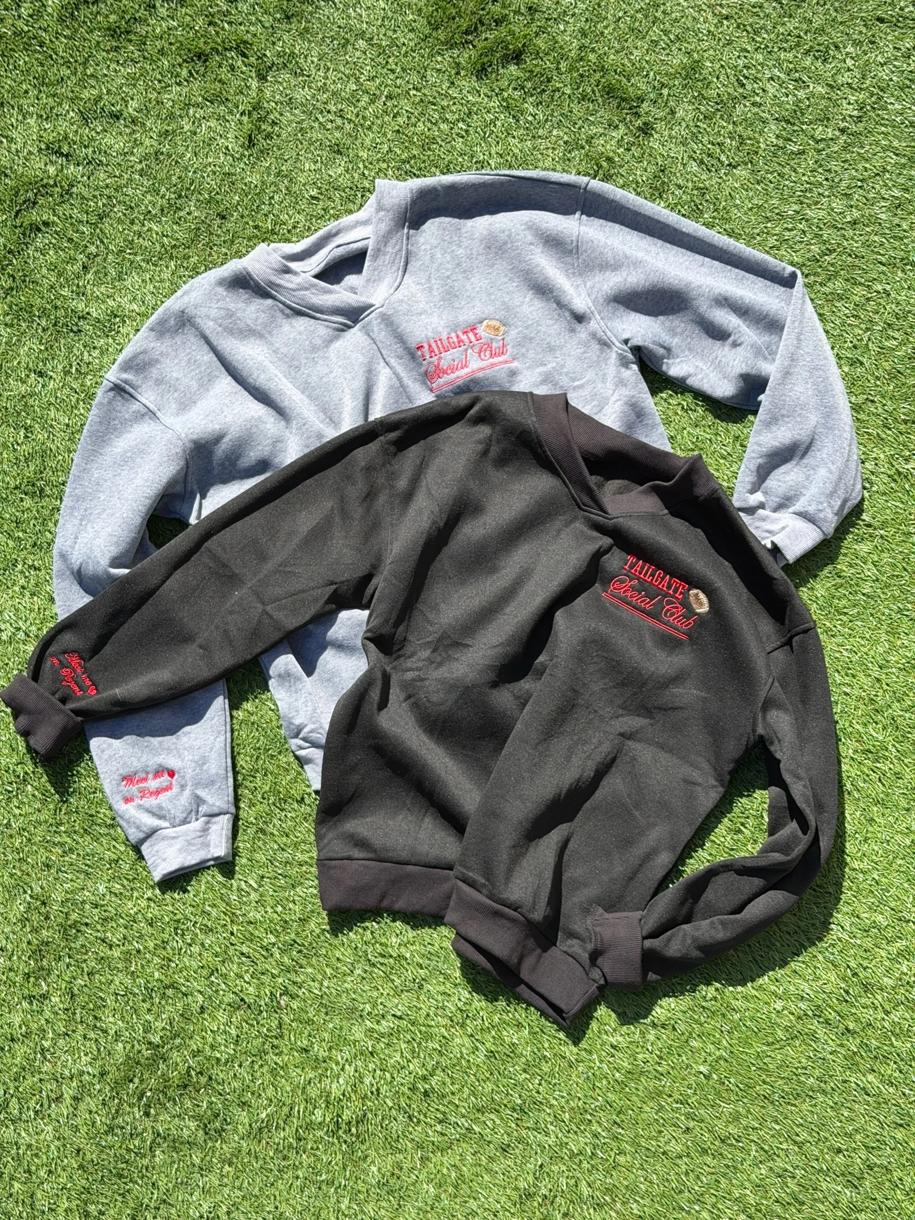 Grey and black vneck crewnecks with Tailgate Social Club on the left chest.