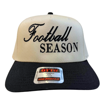 A trucker hat with a cream front and black bill, featuring embroidered text that reads 'Football SEASON'.