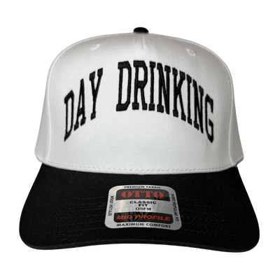 A white and black trucker hat with the words 'DAY DRINKING' embroidered on the front.