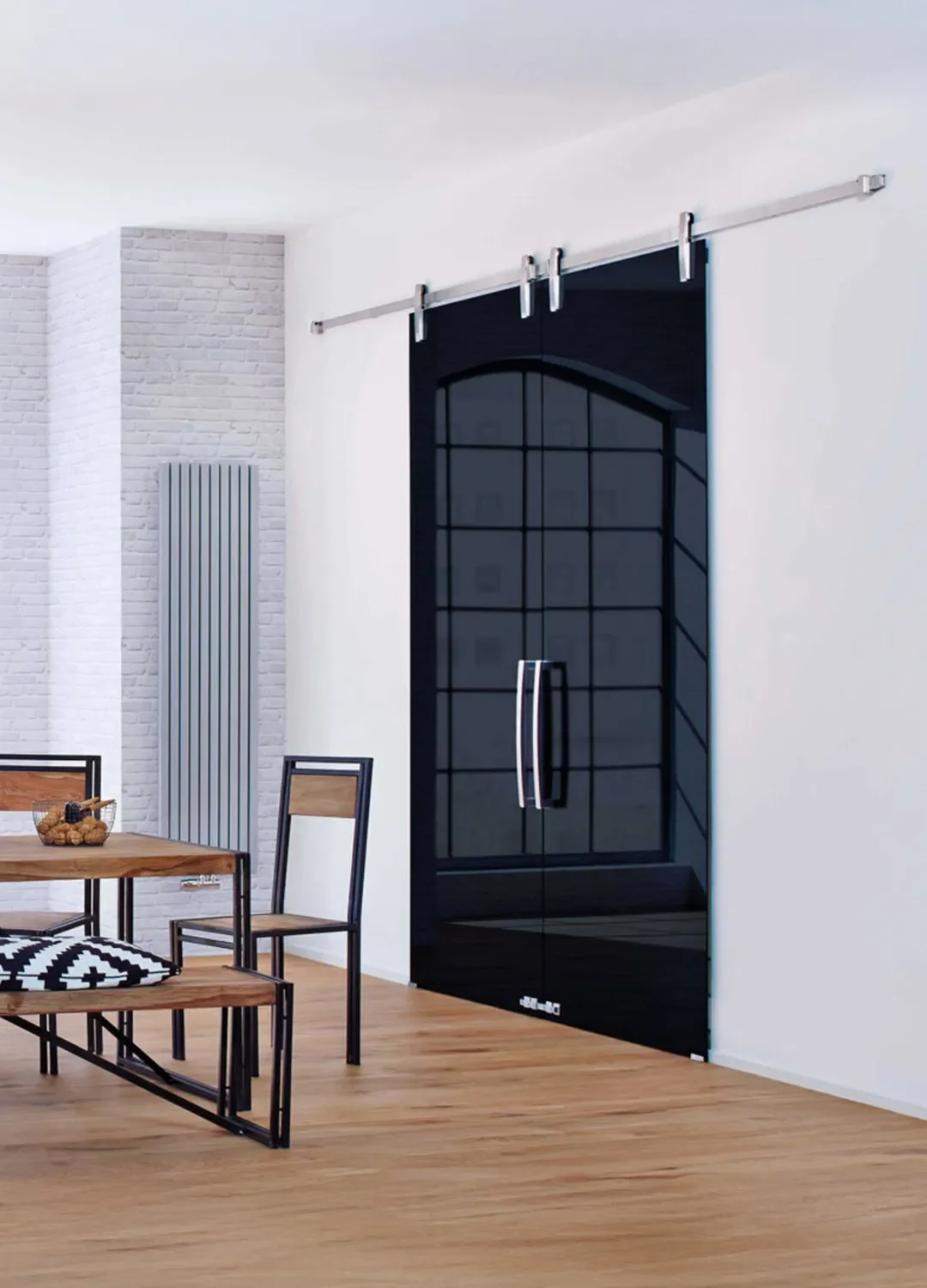 Moderne zweiflügelige Ganzglas-Schiebetür aus dunklem Glas mit hochwertigem Edelstahl-Laufsystem in einem hellen Wohnraum mit Essbereich.