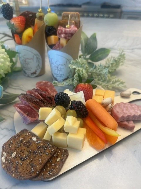 Charcuterie board with cheese, berries, meats, carrots, crackers, and almonds