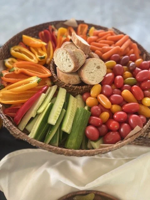 A basket with colorful candy, vegetable sticks, and slices of bread arranged in separate sections.