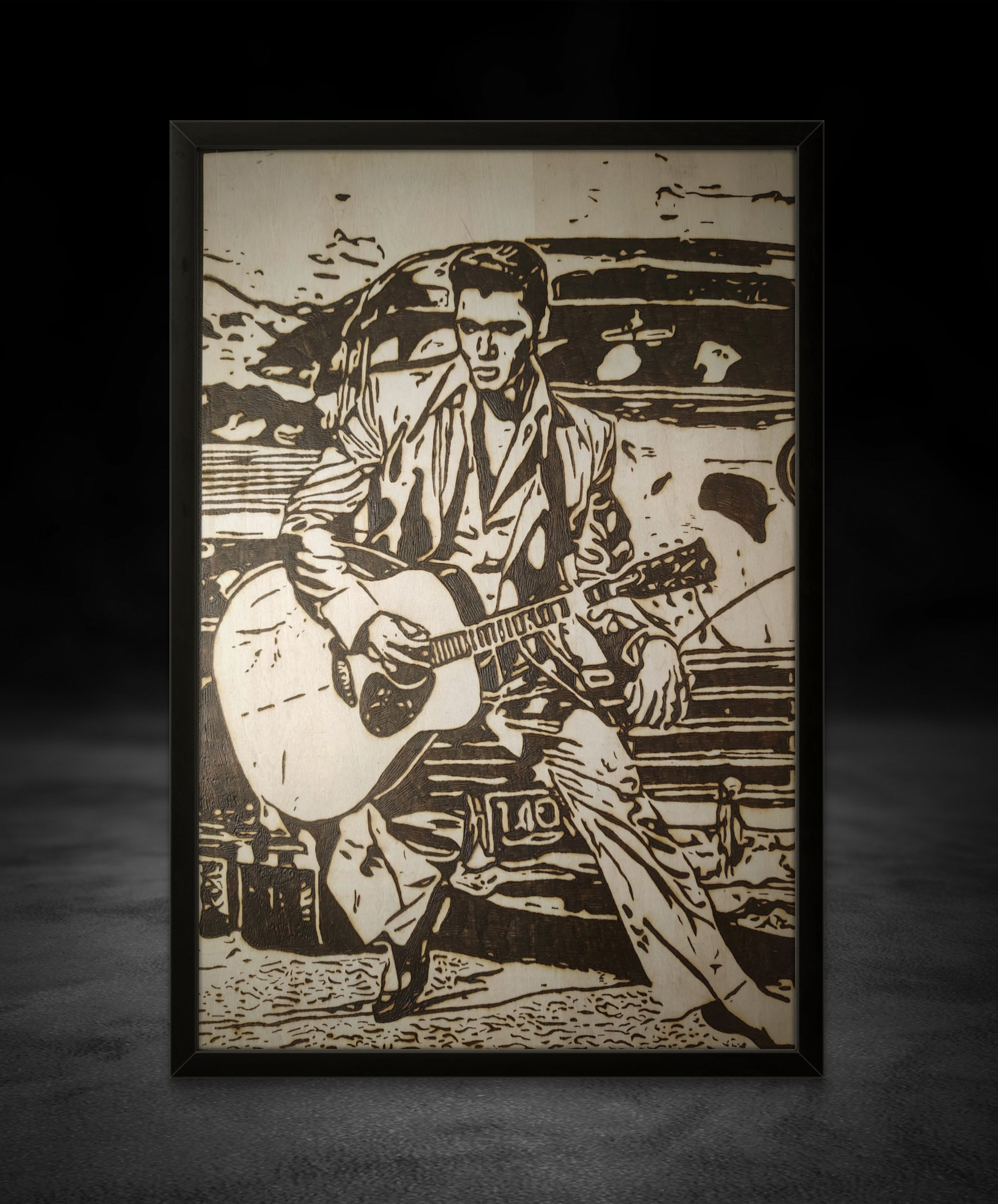 Custom wood-burned artwork depicting a guitarist seated near a vintage Cadillac, hand-burned pyrography etched into natural wood grain.