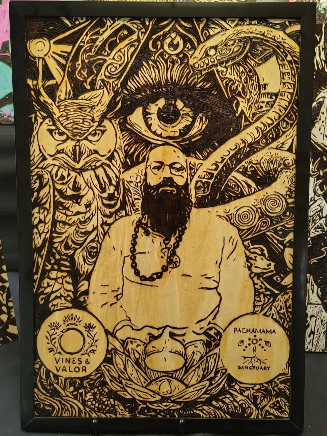 Hand-burned wood artwork depicting a meditative bearded figure surrounded by symbolic spiritual imagery, including an all-seeing eye, owl, serpent, and botanical elements, intricately burned into natural wood using detailed pyrography techniques