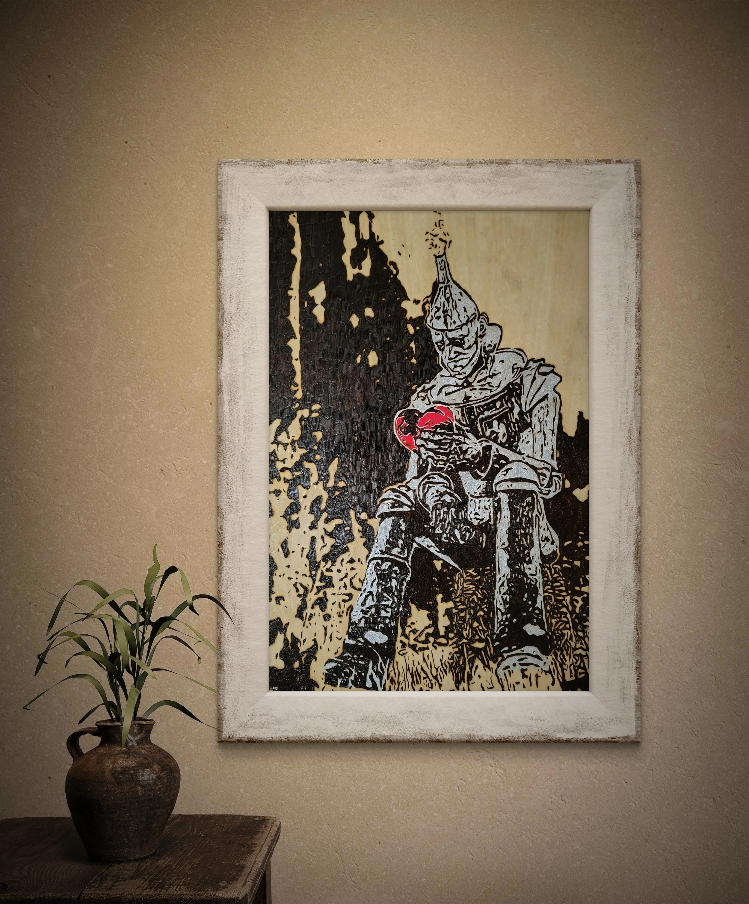 Close-up view of detailed wood-burned wall art featuring a metallic figure and red heart, created by hand on basswood