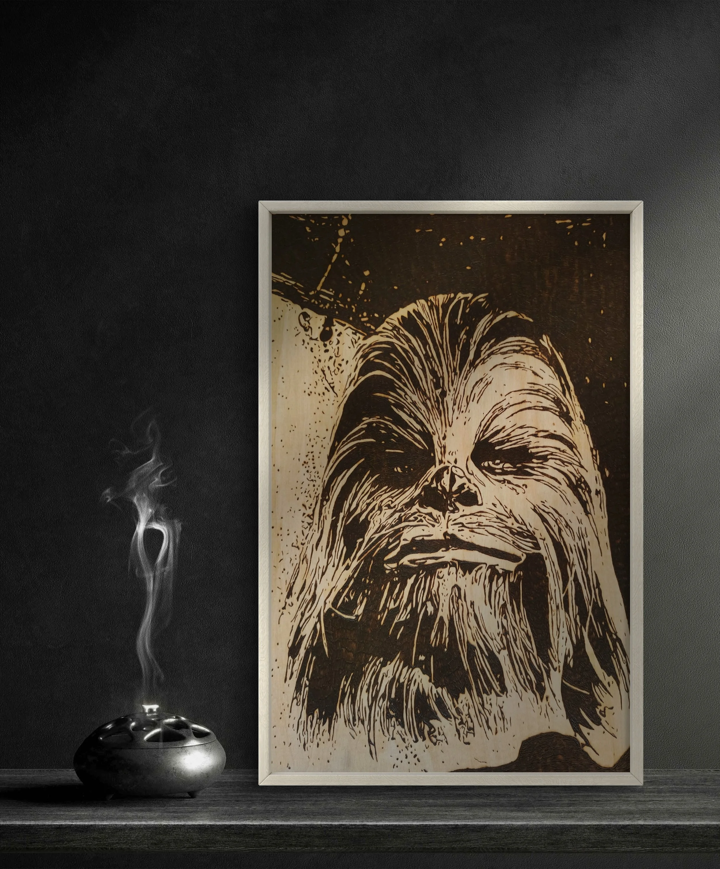 Chewbacca wood-burned artwork displayed in white frame on shelf, handmade pyrography art burned into basswood, Star Wars inspired wall art for office or studio