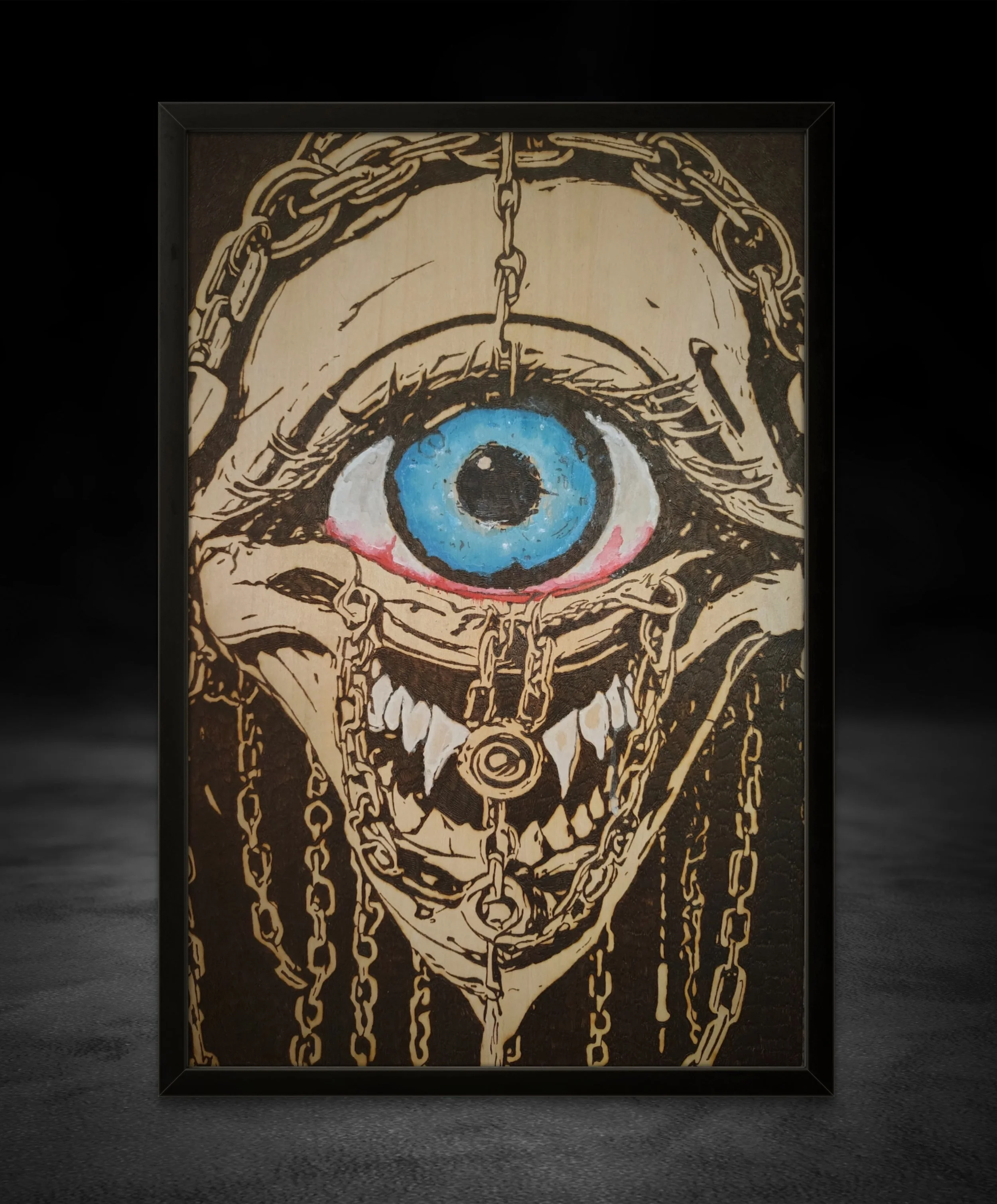 Hand-burned wood burning and pyrography art depicting a surreal chained eye with teeth and blue painted accents, burned into solid basswood as original wall art