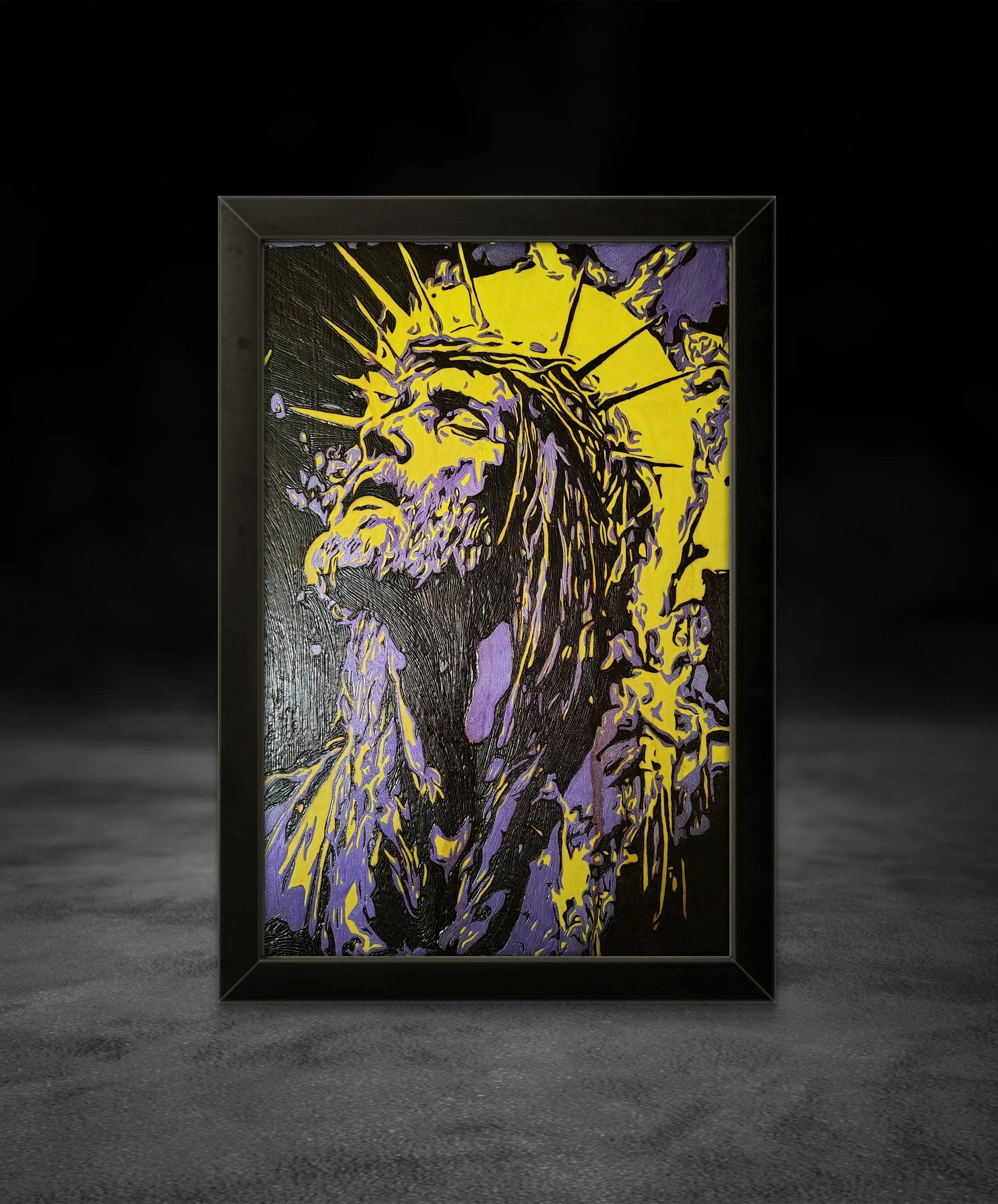 Framed wood burning artwork showing a religious portrait with painted accents, handcrafted on natural basswood