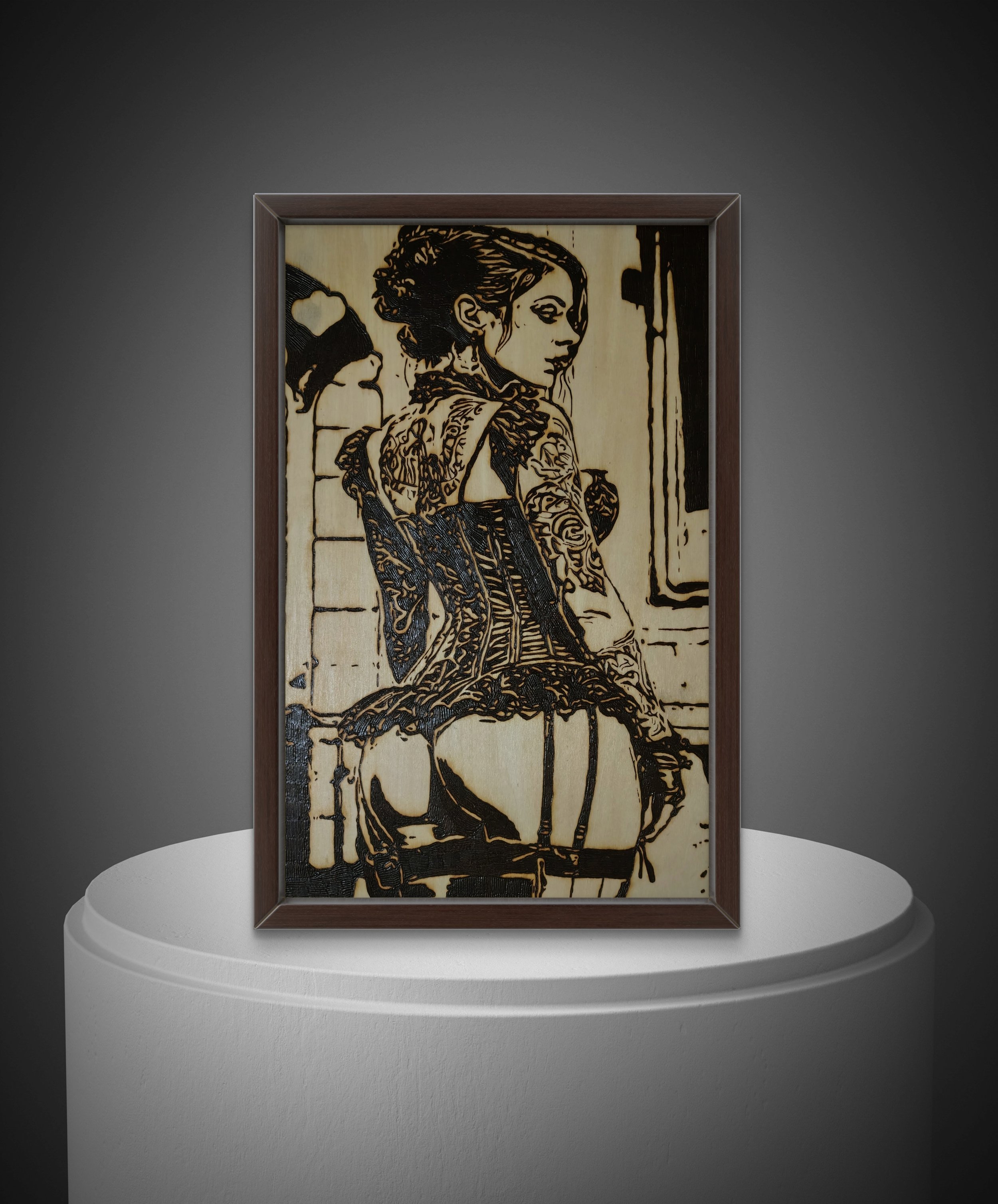 Framed wood burning wall art depicting a restrained female figure with intricate hand-burned line work