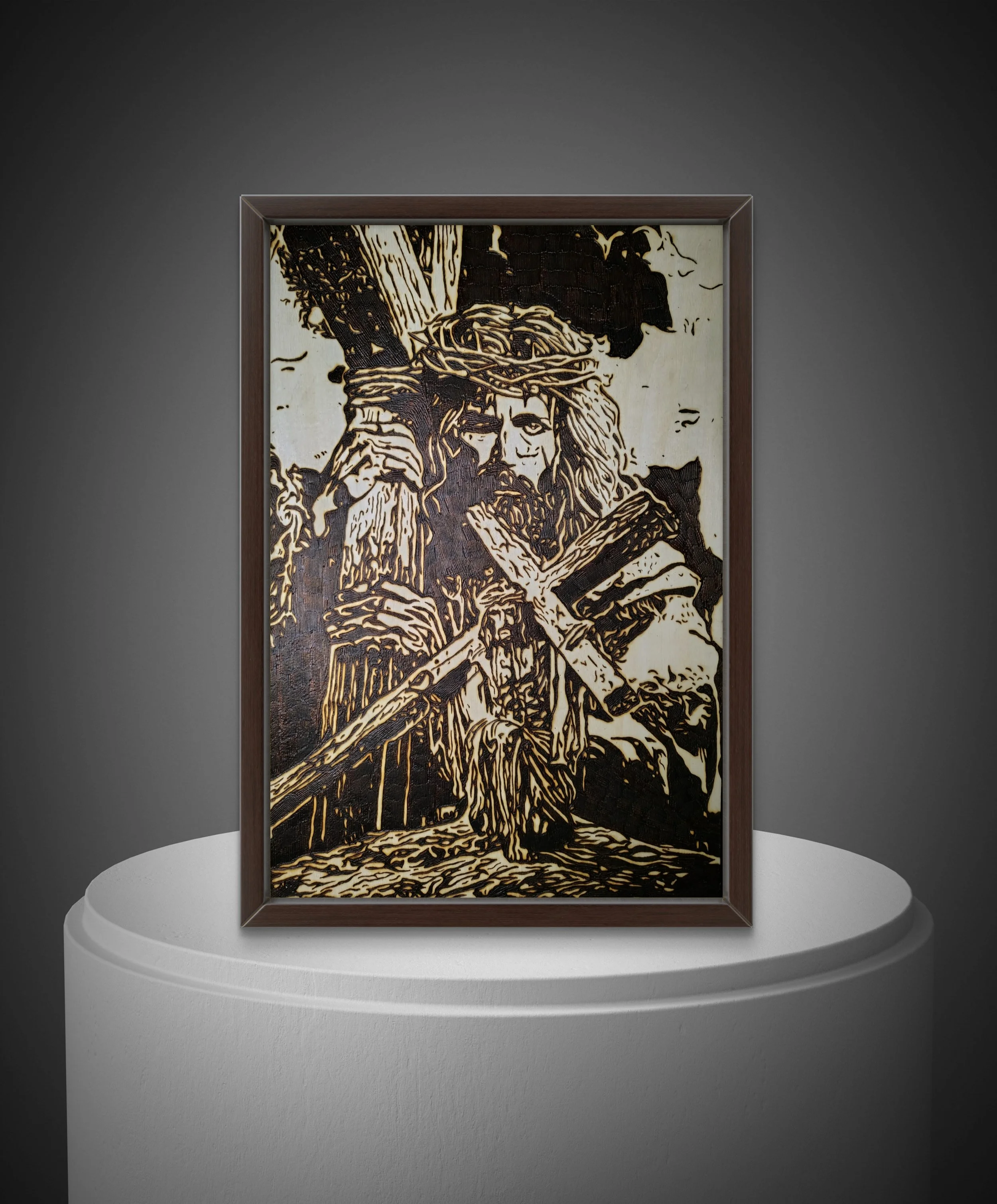Framed wood burning artwork showing a symbolic religious figure bearing a cross, handcrafted on natural basswood