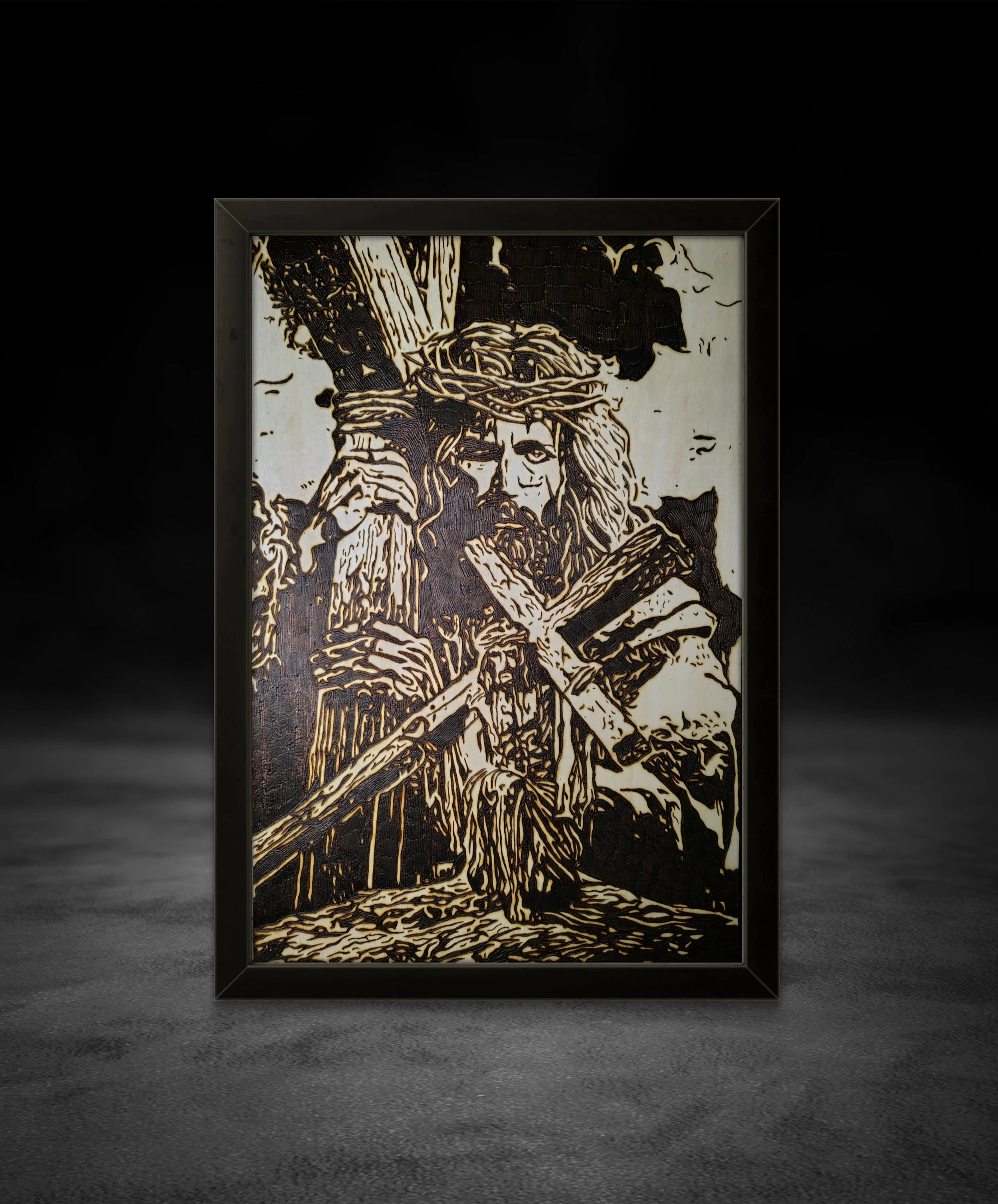 Hand-burned wood art depicting a figure carrying a cross, burned into basswood with bold contrast and detailed line work