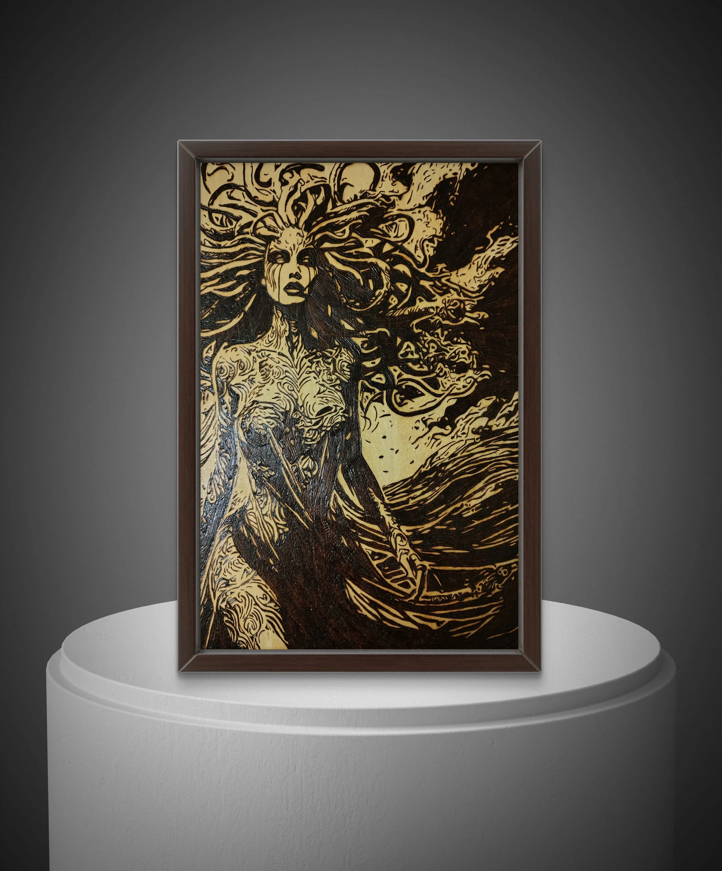 Hand-burned Medusa wood artwork framed on dark background