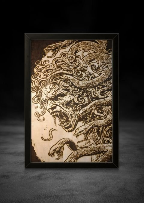 Hand-burned wood artwork showing a snarling demonic creature with flowing organic lines, carved into basswood with intense texture and motion