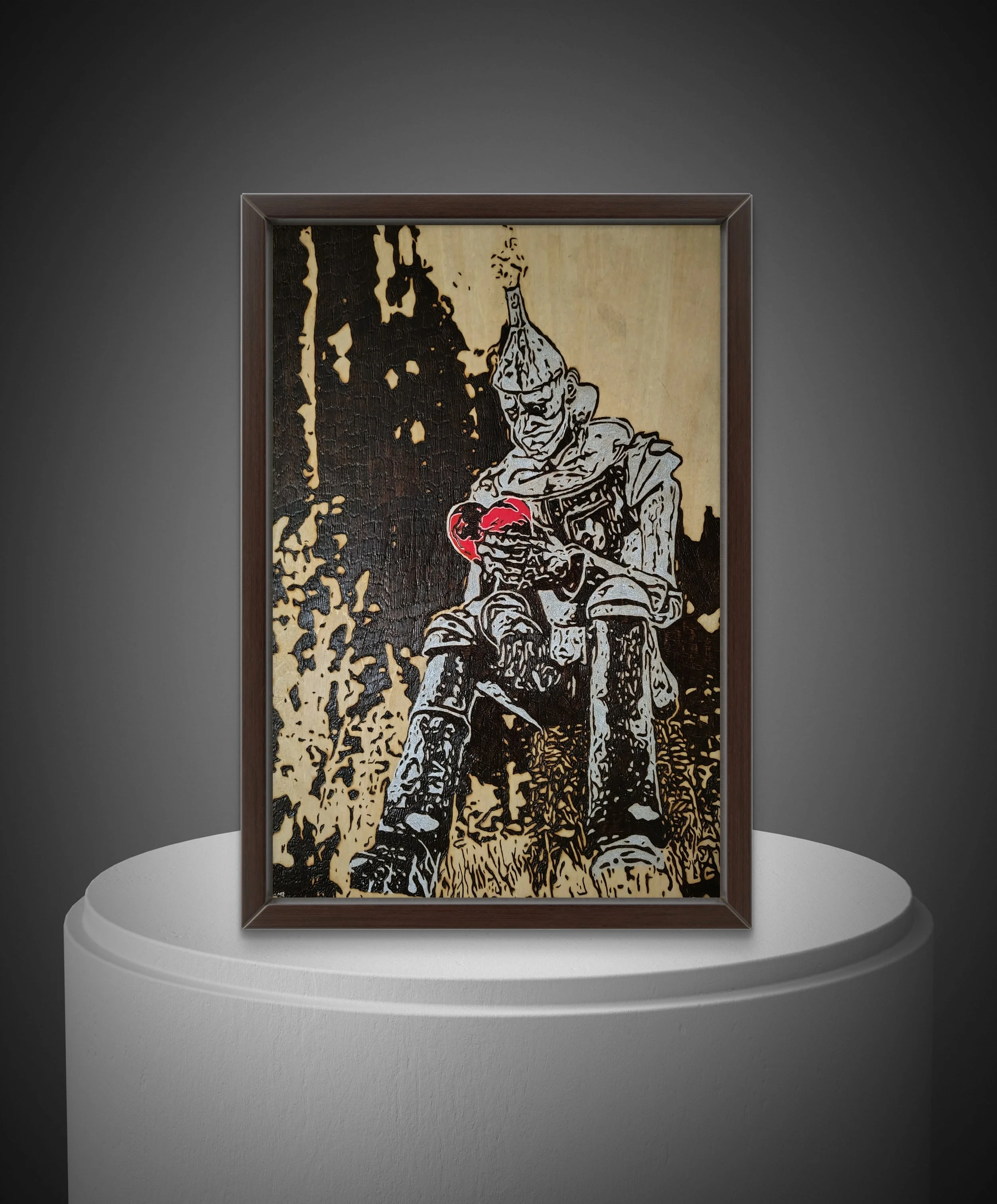 Framed wood burning artwork showing a symbolic tin man figure with a heart, handcrafted on natural basswood