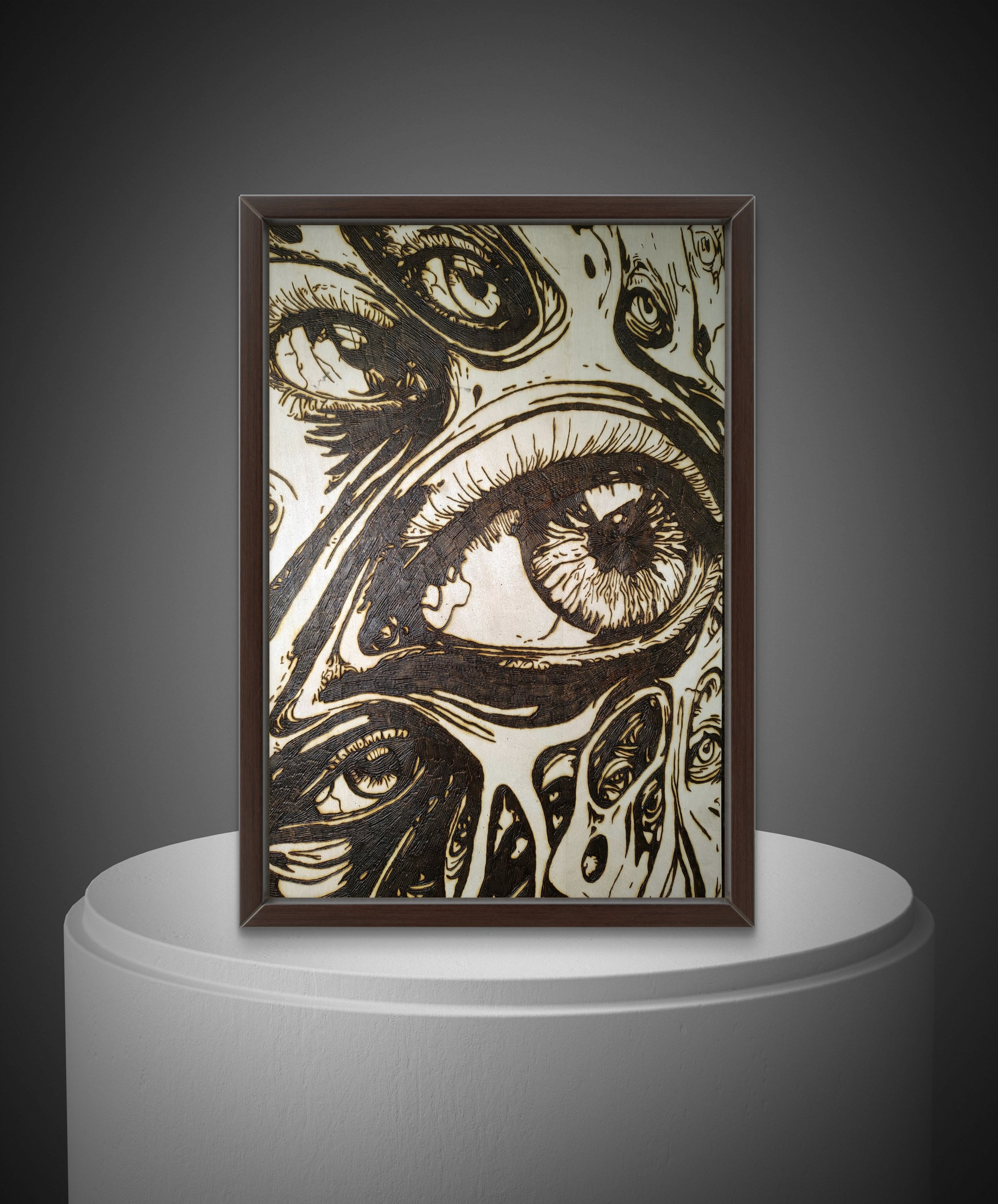 Hand-burned wood artwork depicting multiple overlapping eyes, burned into basswood with high-contrast line work