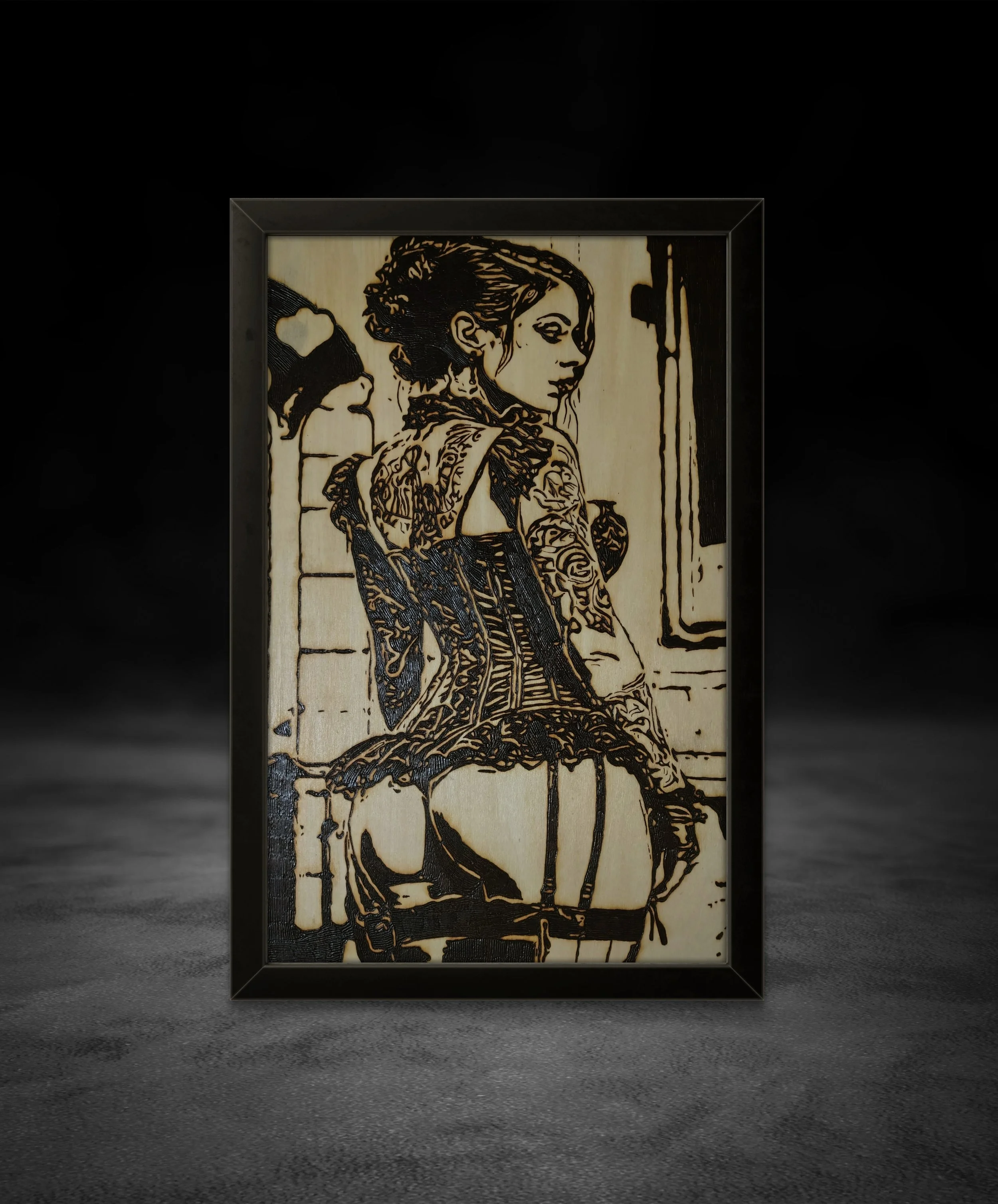 Hand-burned wood artwork of a corseted woman turned sideways, burned into basswood and framed in black