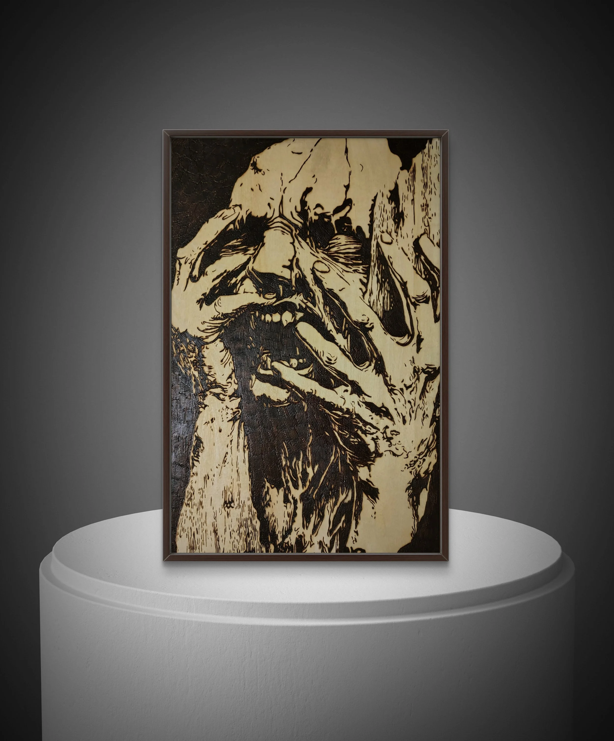 Framed hand-burned basswood artwork showing intricate line work and emotional imagery, photographed on a pedestal against a dark background