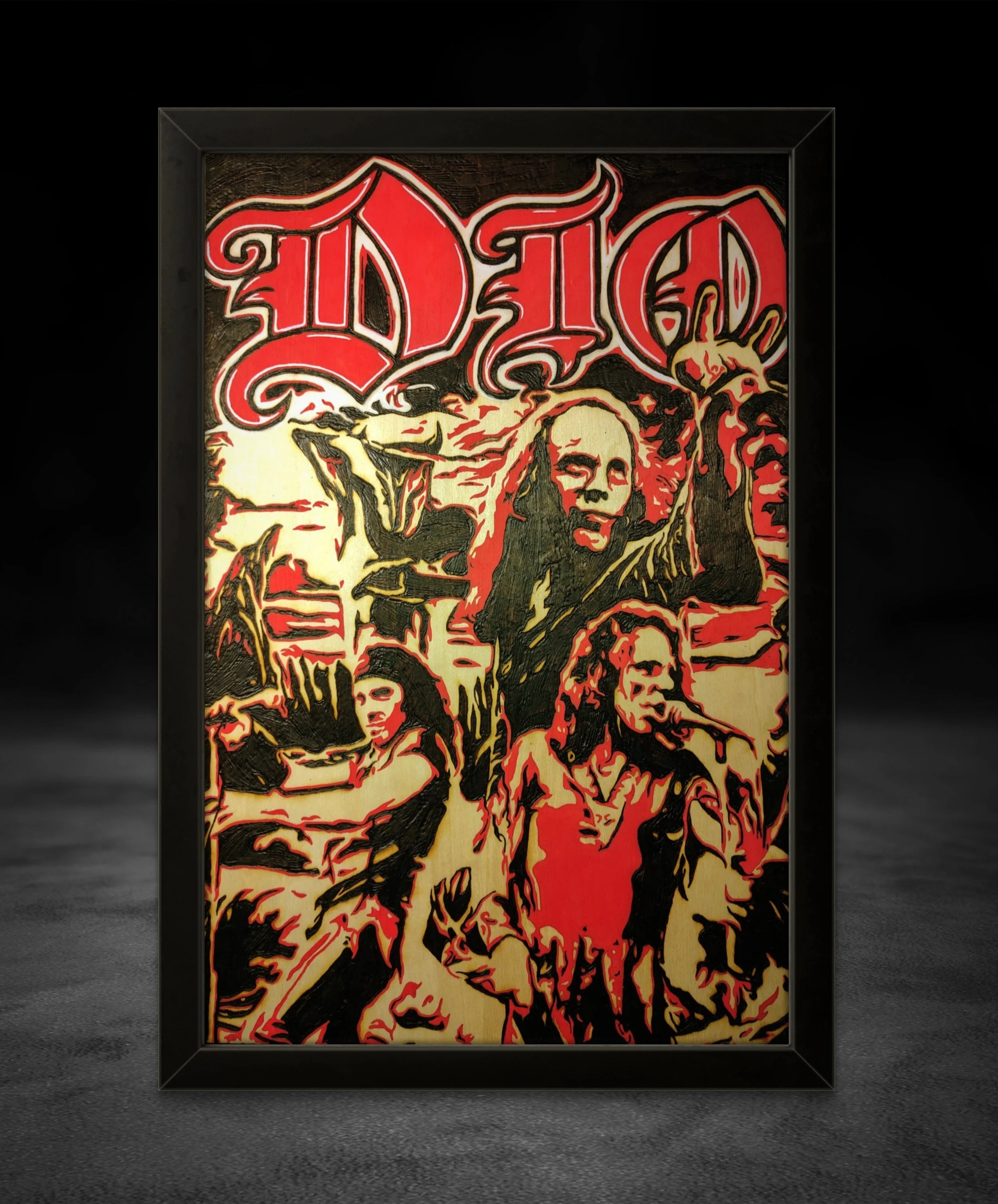 Hand-burned wood art featuring the band Dio in a dramatic red painted collage composition, burned into basswood with heavy line work and high-contrast shading with a black frame