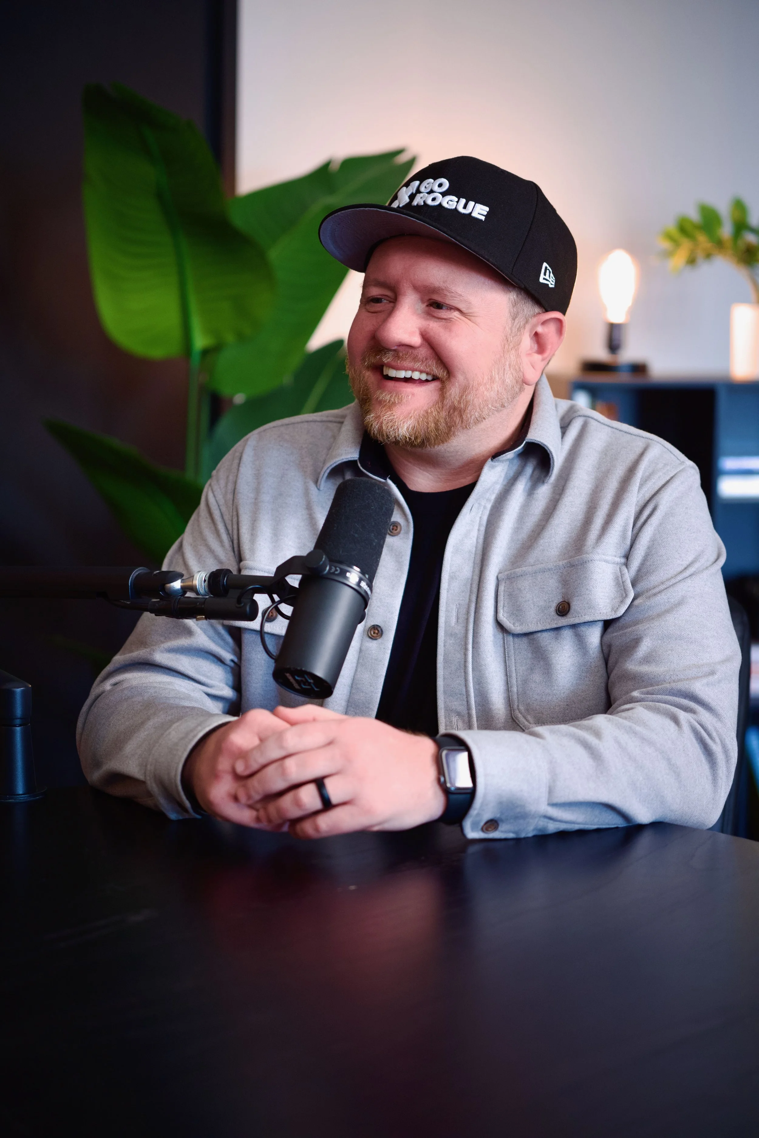 Bryan Fittin from Go Rogue Studio sitting and smiling at a podcast table