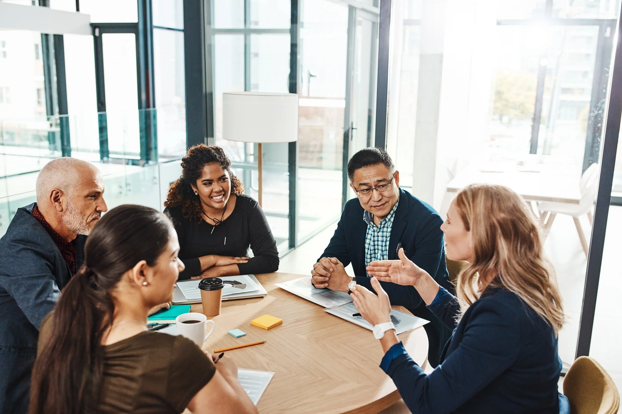 Five people sit around a round table in an office, engaged in a discussion about housing development  in Tennessee.