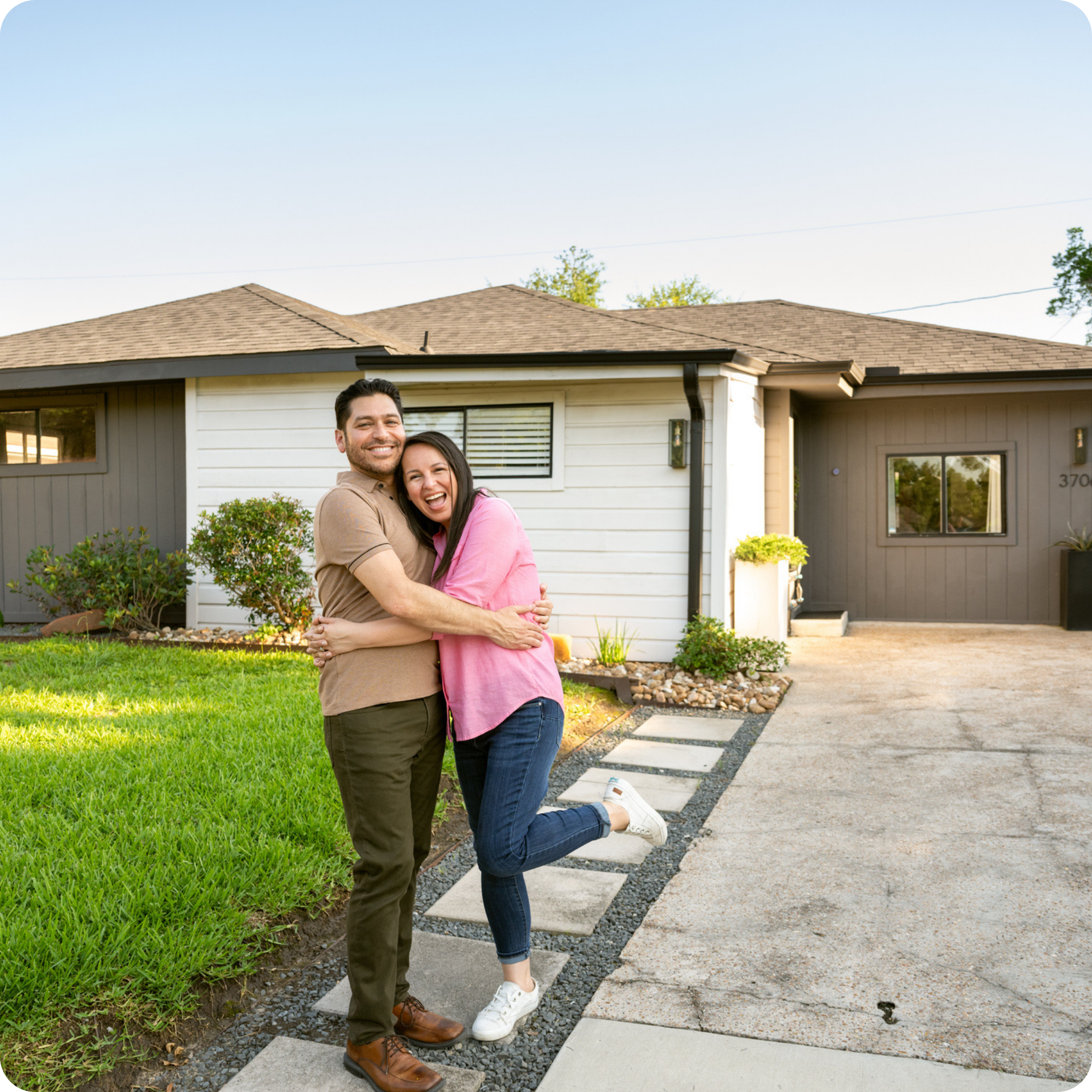 A couple hugging with an excited expression in front of a newly bought affordable Tennessee home