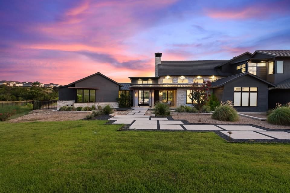 Modern house with well-maintained lawn and pathway during sunset.