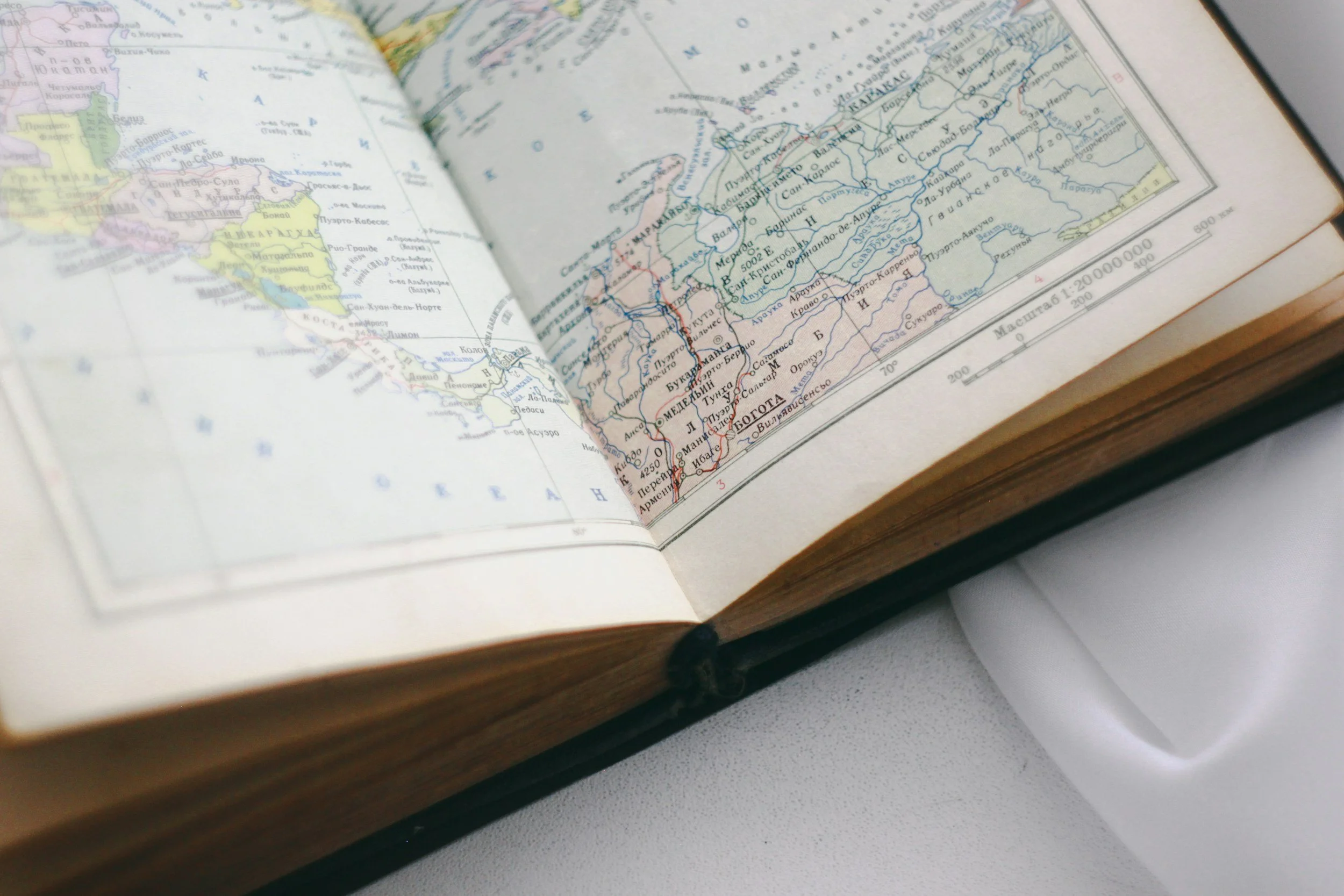 Open book displaying a map of Russia with blue rivers and political boundaries, placed on a white surface.