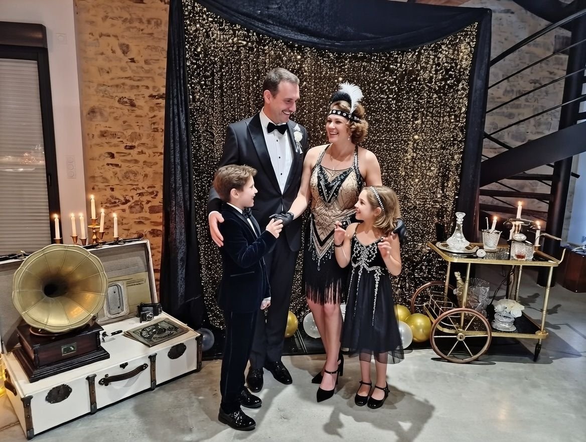 Décor Gatsby pour anniversaire avec famille et enfants posant devant un fond années 20 à Nantes.