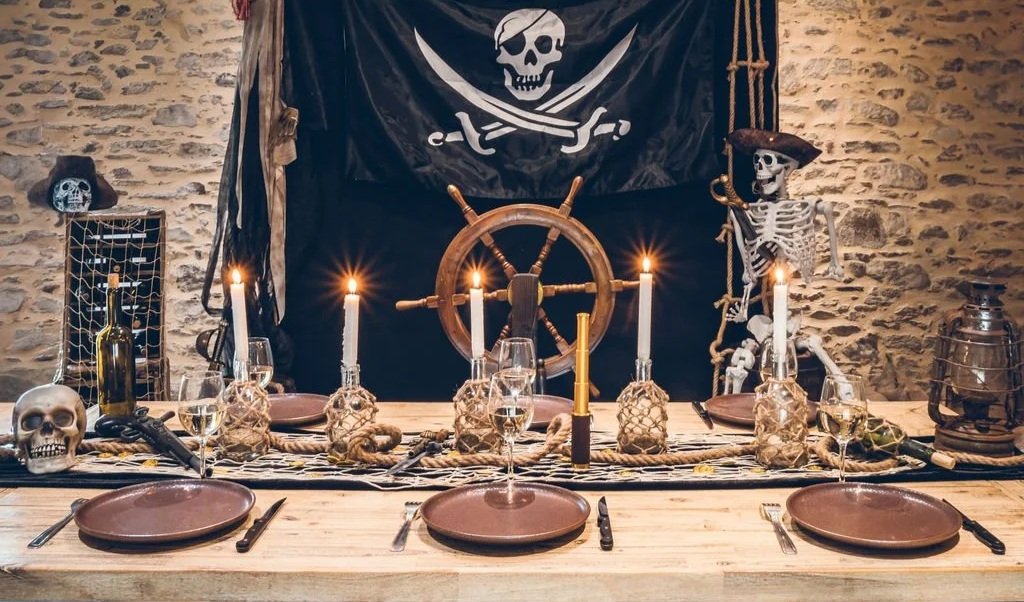 Détail table pirate immersive avec crâne décoratif, bouteilles en verre et bougies – location Nantes