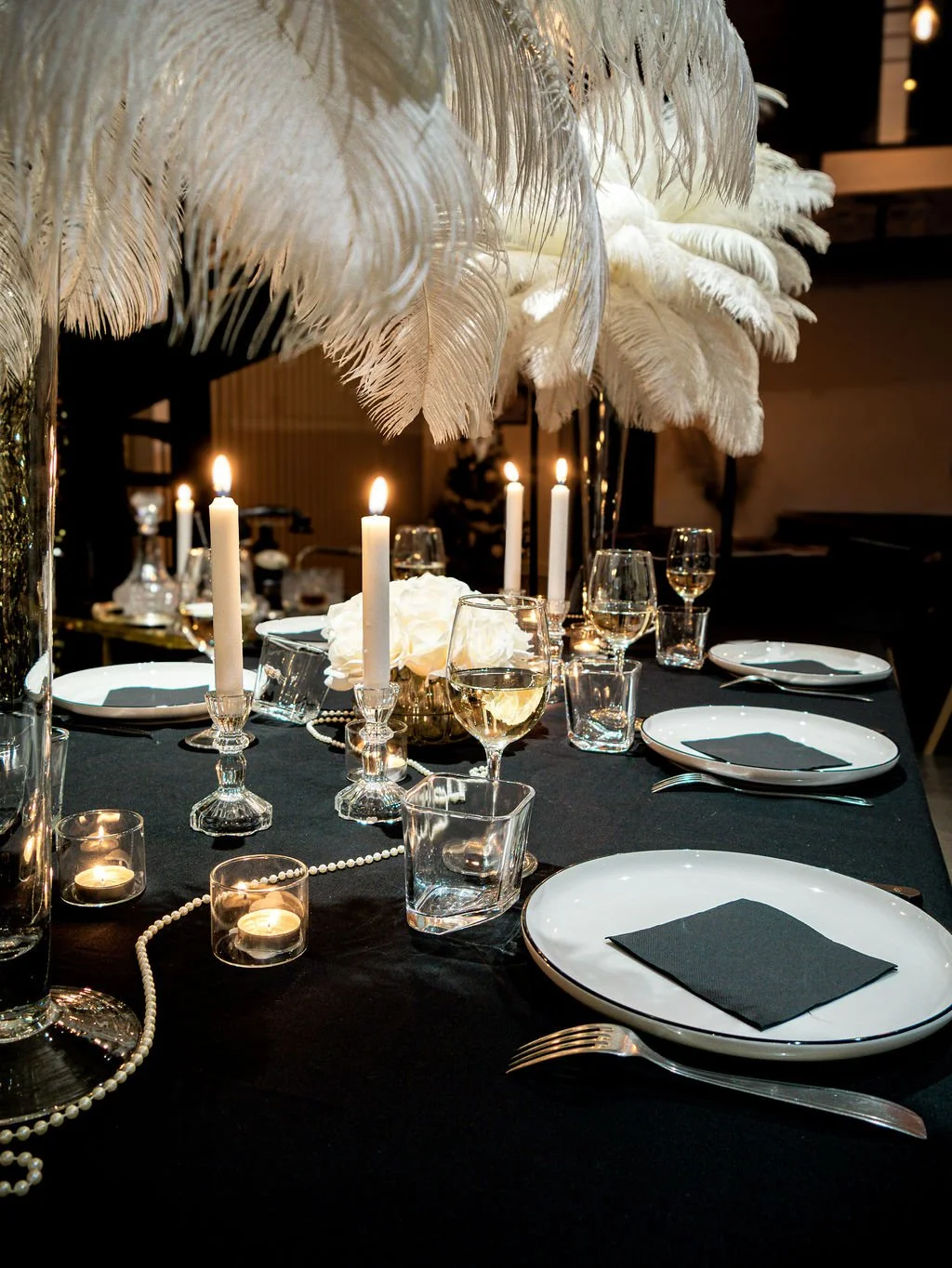 Décoration de table Gatsby immersive à louer à Nantes avec plumes, bougies et vaisselle élégante